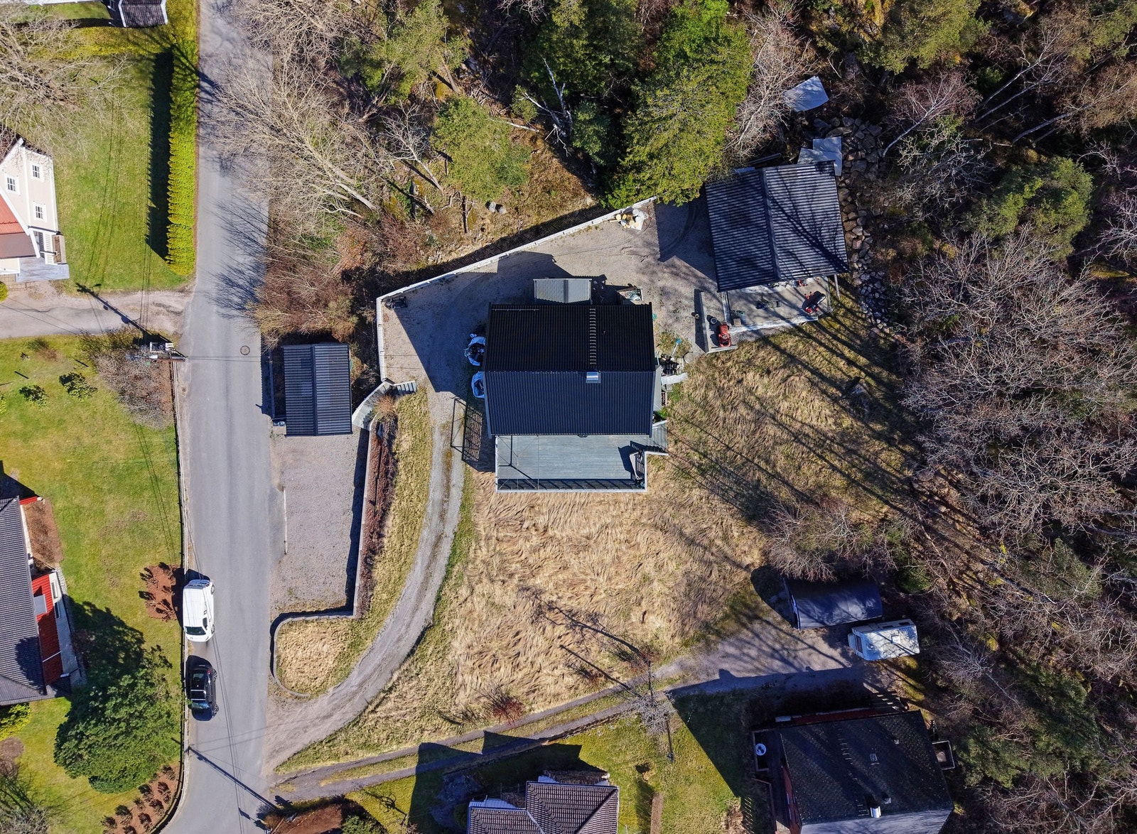 Nede mot veien er det garasje for 1 bil, og øverst i gårdsplassen, bak huset, er det en verkstedgarasje. Galleribilde