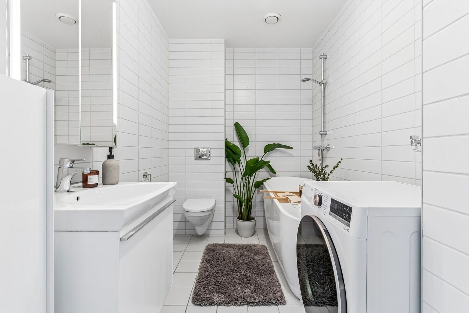 Begge badene har hvit glatt innredning og vegghengt toalett. Badet i 2. etasje har også opplegg for vaskemaskin og tørketrommel. Galleribilde