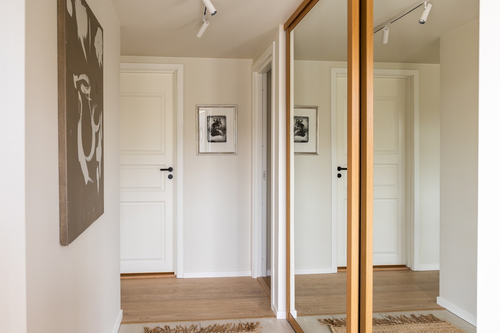 Boligen har inngang fra den hellelagt uteplassen til en flislagt entré med gulvvarme. Veggene har lysmalt panel og langs den ene veggen er det en romtilpasset skyvedørsgarderobe med speilfronter Galleribilde