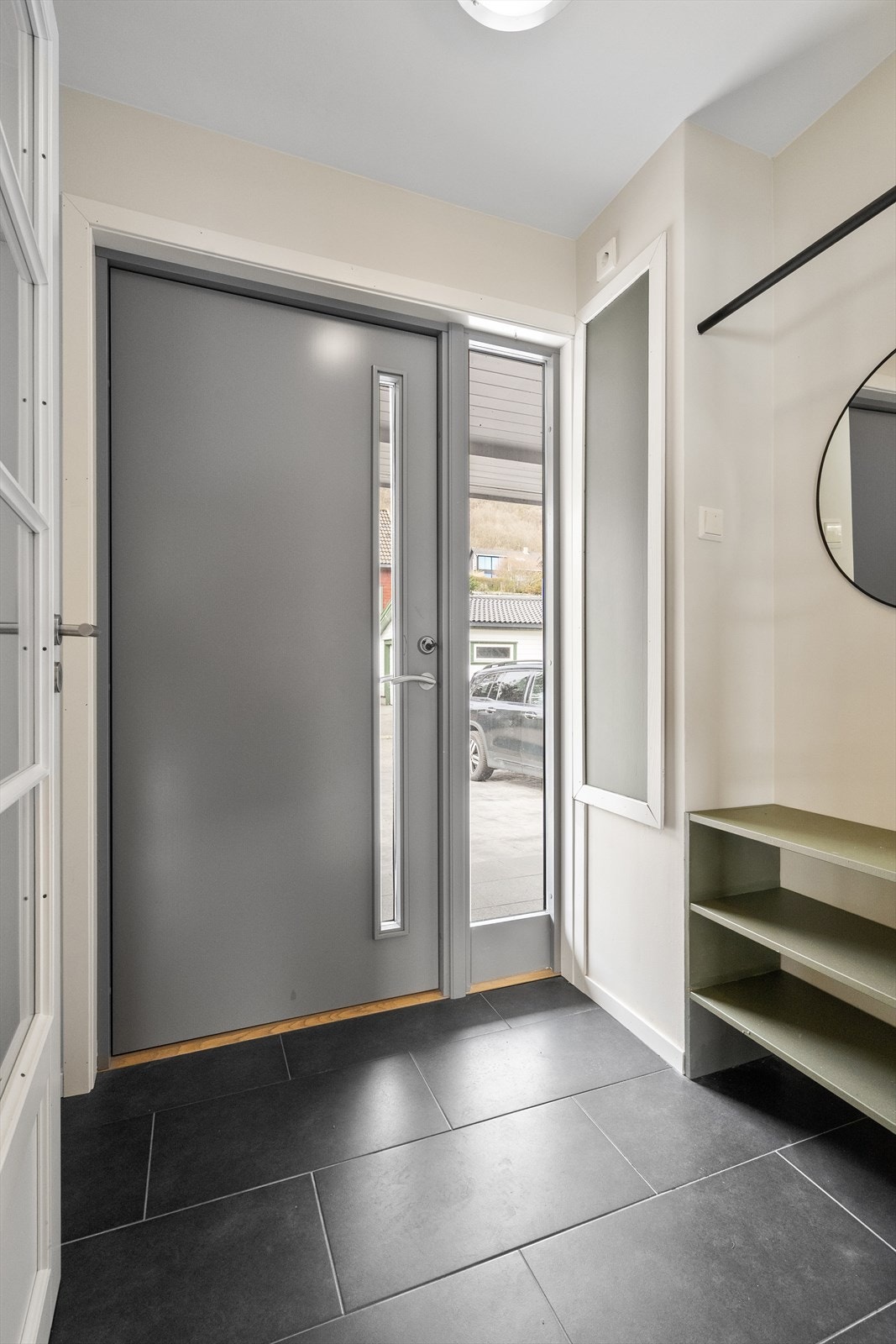 Velkommen inn. Entréen har store, mørke fliser på gulvet og plass til oppbevaring av yttertøy. Galleribilde