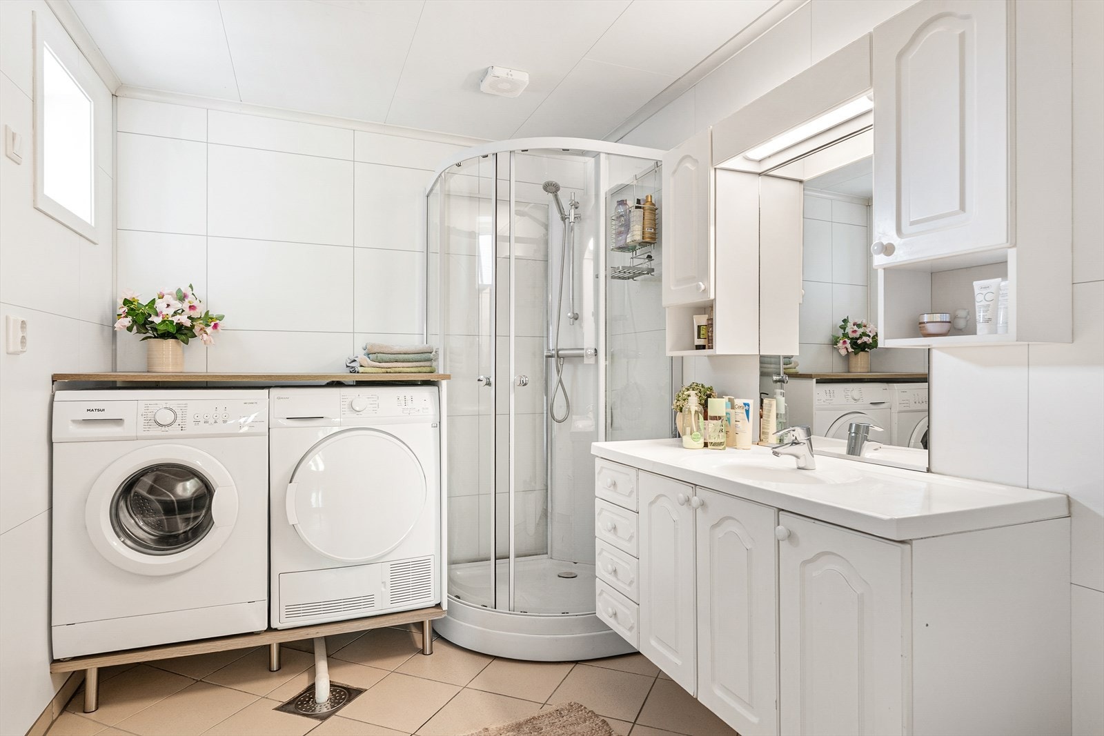 Badet i leiligheten ble oppgradert i 2022 med fliser på gulv og baderomsplater på vegger. Her er det også opplegg for vaskemaskin. Galleribilde