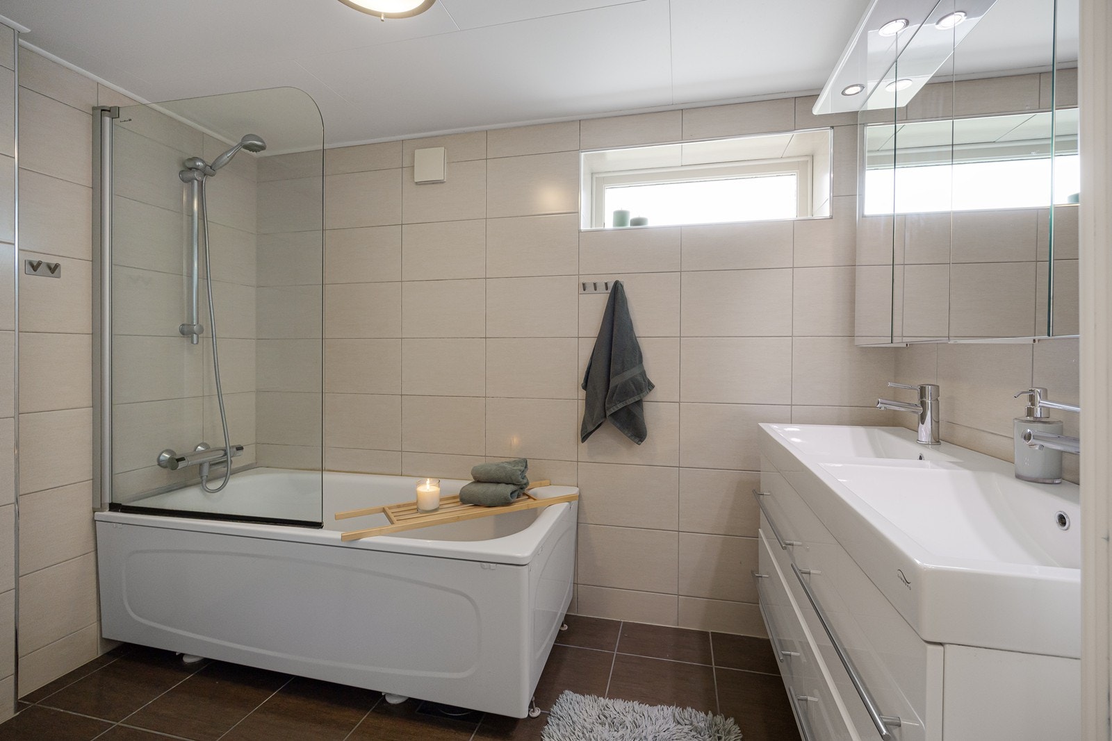 Badet i hoveddelen har innredning med heldekkende dobbelservant over skuffeseksjon og i overkant et stort speilskap. Galleribilde