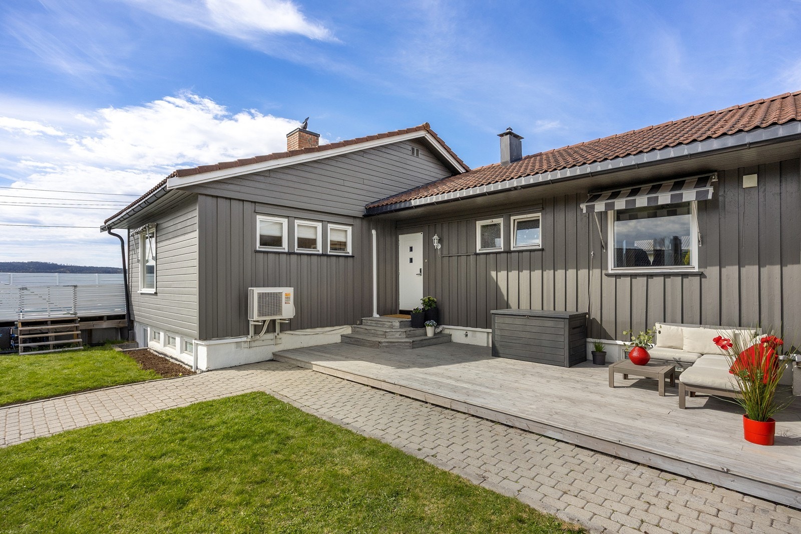 Fra gårdsplassen er det hellelagt steingang til det delvis overbygde inngangspartiet. Her sørger en stor markterrasse for en hyggelig velkomst til boligen. Galleribilde