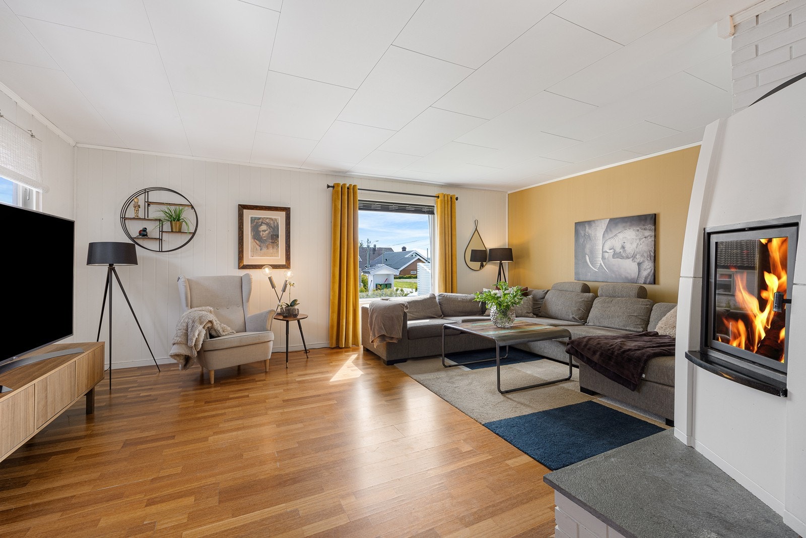 Parkett på gulvet kombineres med vegger malt i hvitt og en varm gultone. Galleribilde