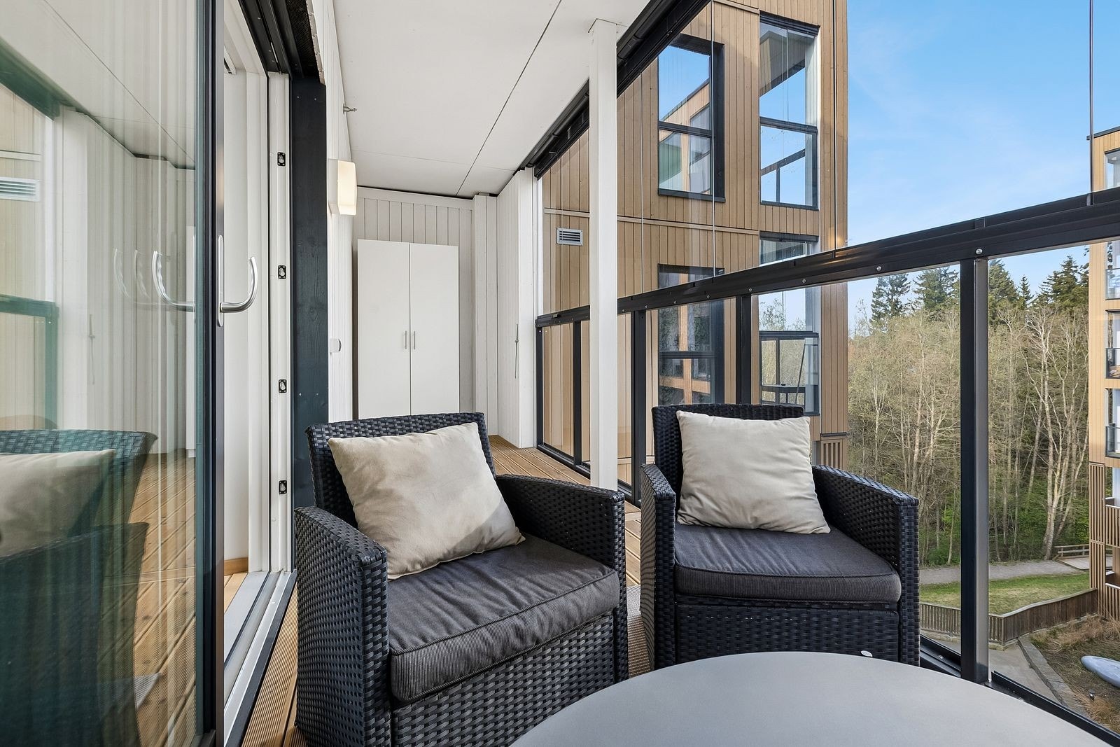 Innglasset balkong med hyggelig oppholdsplass og rom for utemøbler. Galleribilde