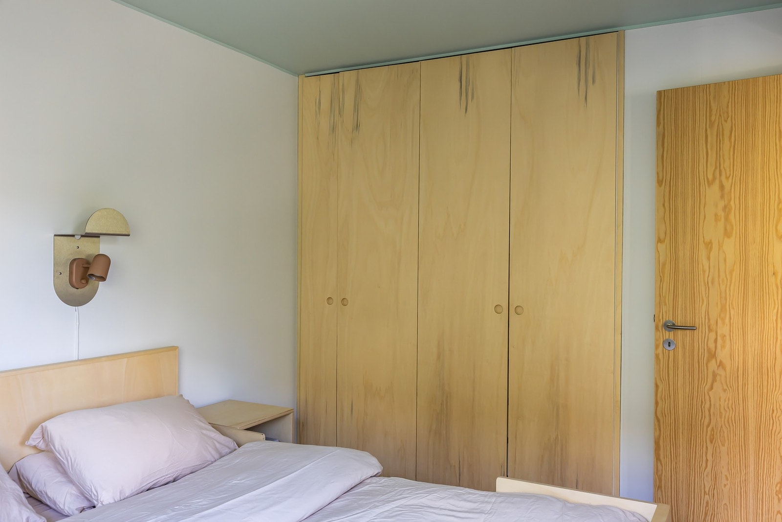 Veggdekkende garderobe i lyst trevirke med enkle, runde knotter. Galleribilde