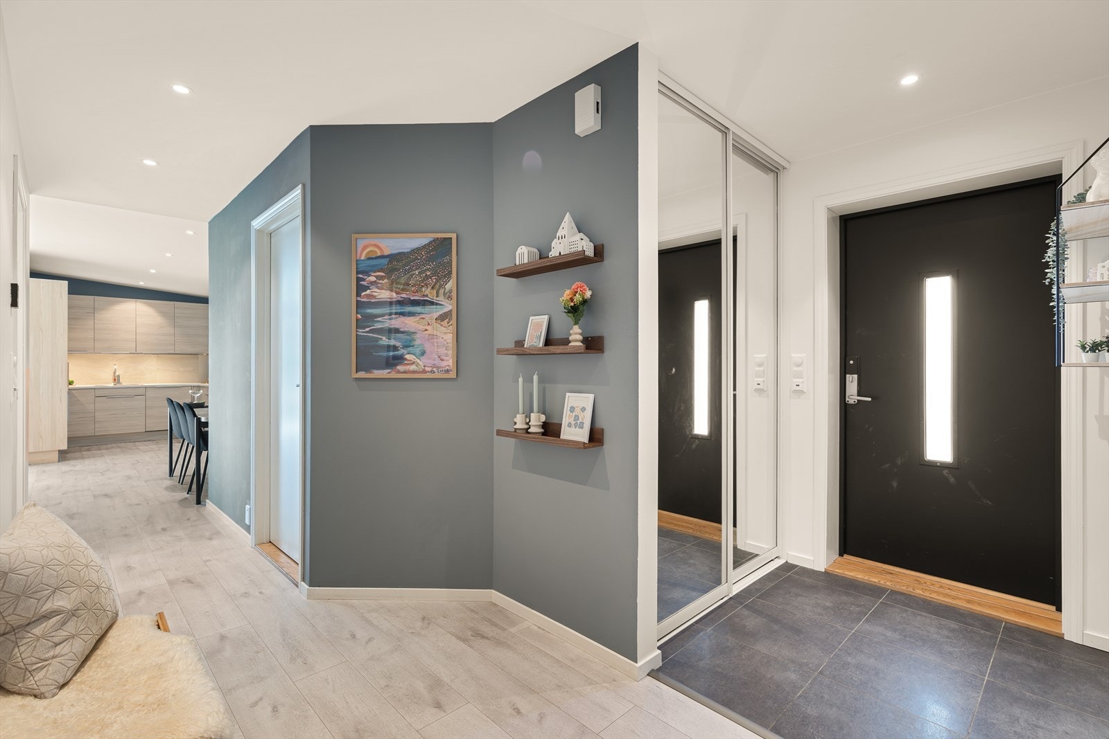 Entréen er lys og innbydende med fliser på gulv og skyvedørsgarderobe med speil. Galleribilde