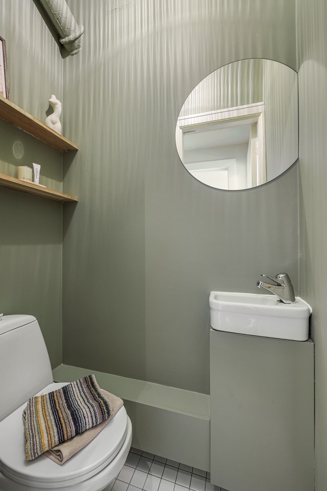 Toalettrommet har flislagt gulv, malte vegger og naturlig avtrekk. Rommet er innredet med servant og wc. Galleribilde