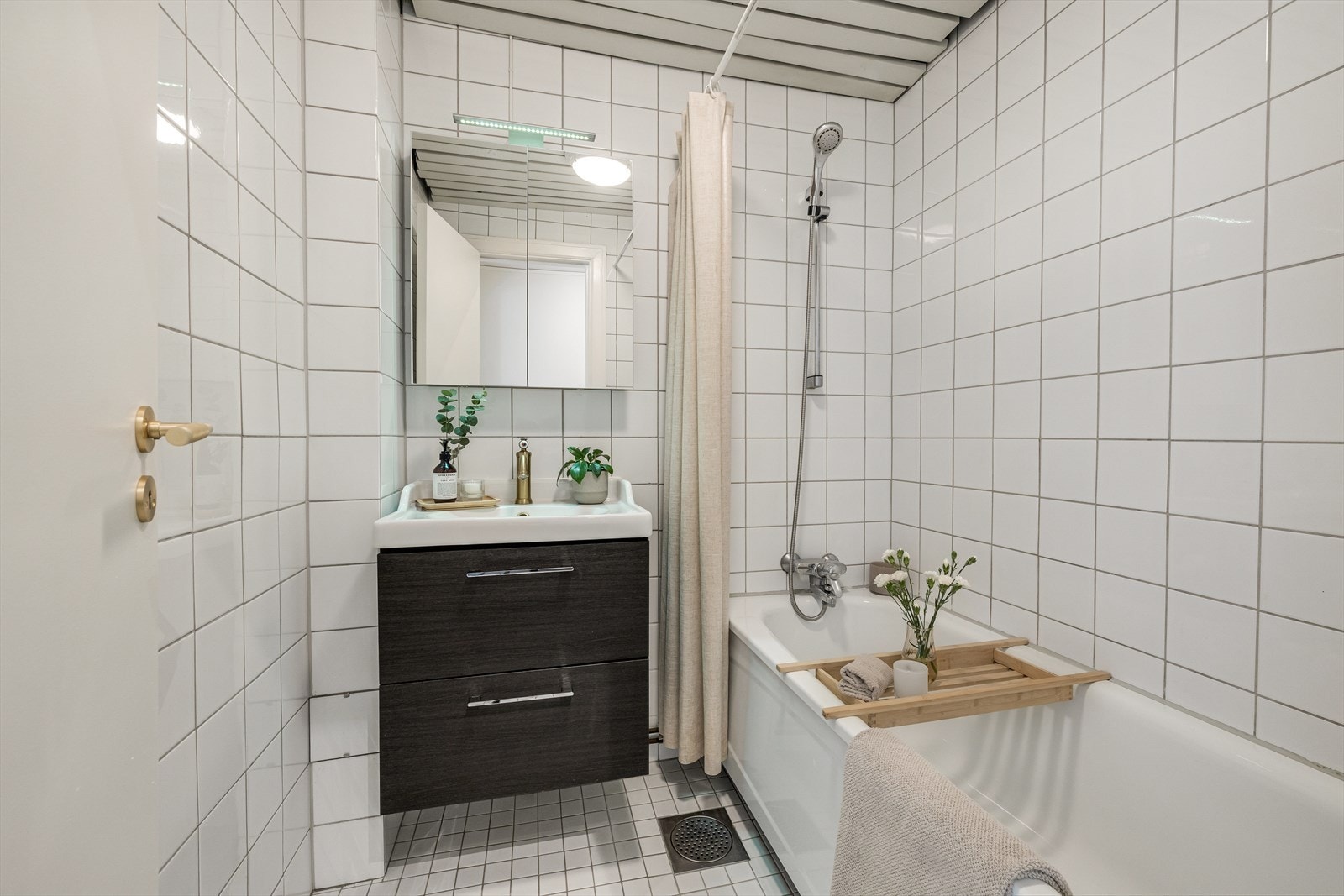 Badet har mosaikkfliser på gulv med gulvvarme, fliser på vegger og profilplater i tak. Galleribilde