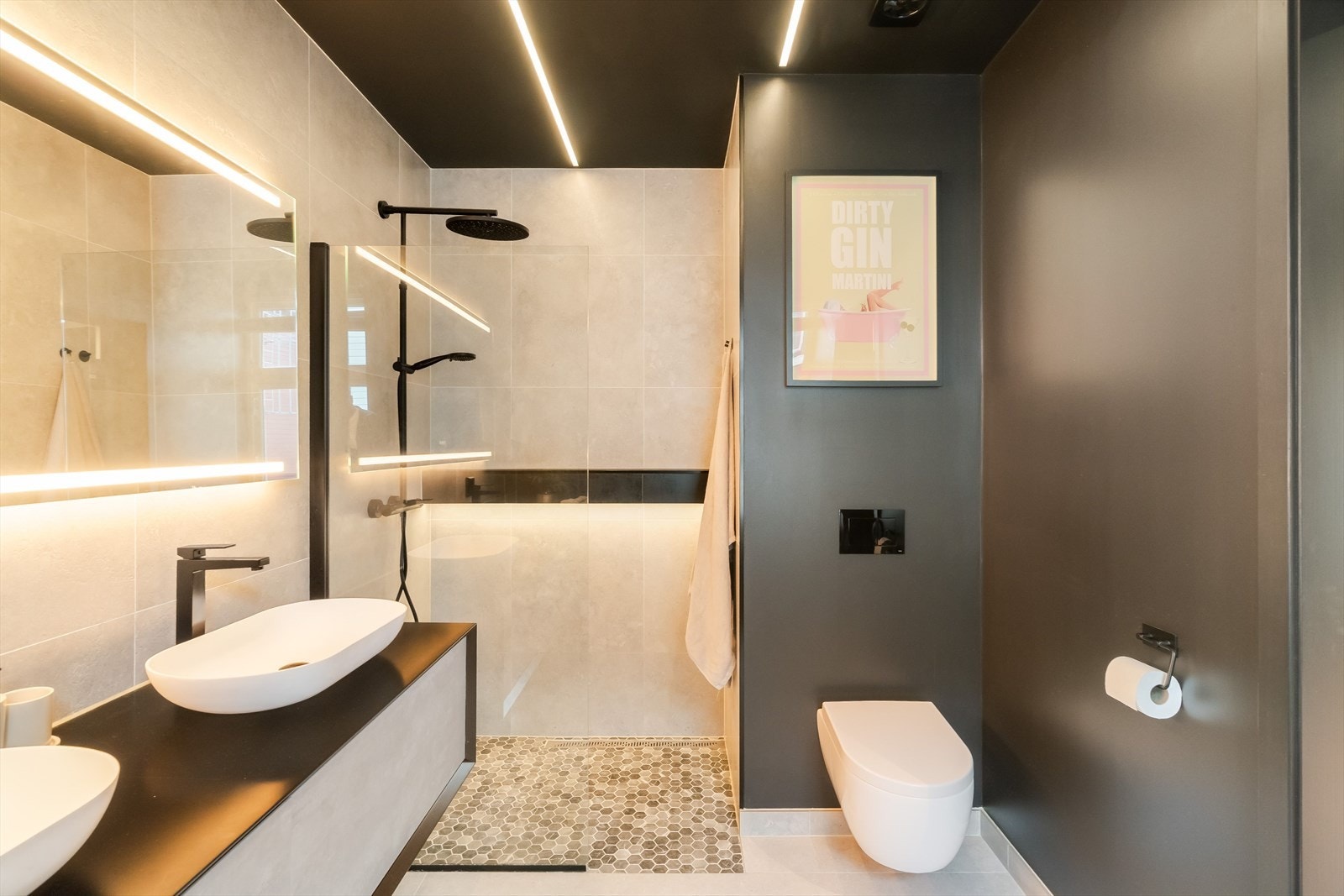 Badet har regnfallsdusj med en innfelt og lyssatt hylle, og mosaikkfliser i dusjensonen. Veggghengt toalett og mekanisk avtrekk for god ventilasjon. Galleribilde