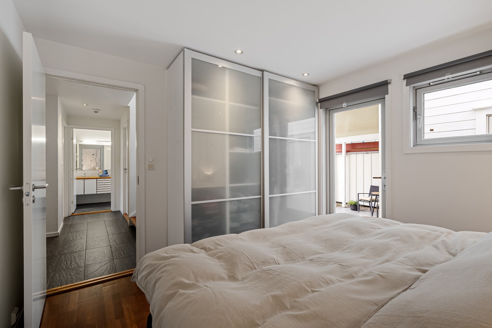 Det er har parkett på gulv, malte veggflater og tapet, romslig skyvedørsgarderobe med rikelig oppbevaringsplass og plass til stor dobbeltseng og nattbord. Galleribilde
