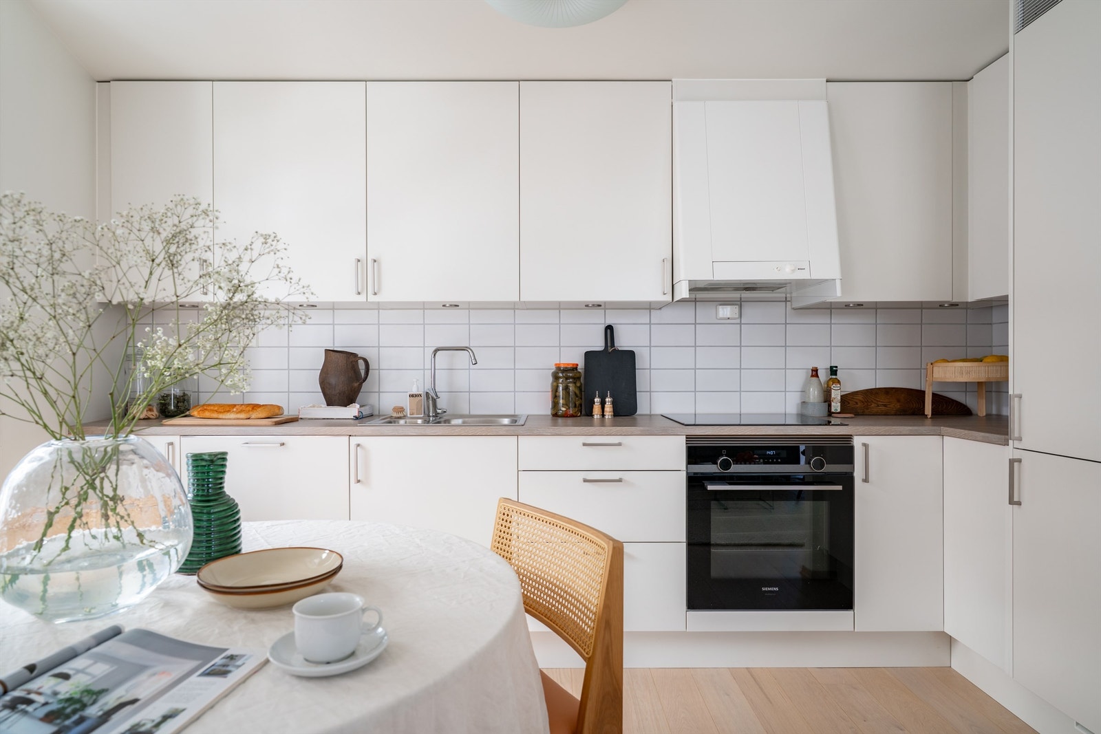 Kjøkkeninnredning fra Sigdal med integrert kjøl/fryseskap, oppvaskmaskin, platetopp og stekeovn. Galleribilde