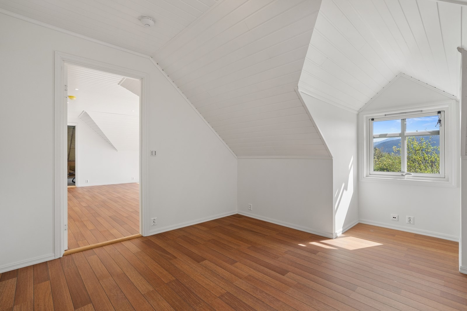 Soverommene på loftet har en gjennomgående stil med lyse, malte flater og laminatgulv. Galleribilde