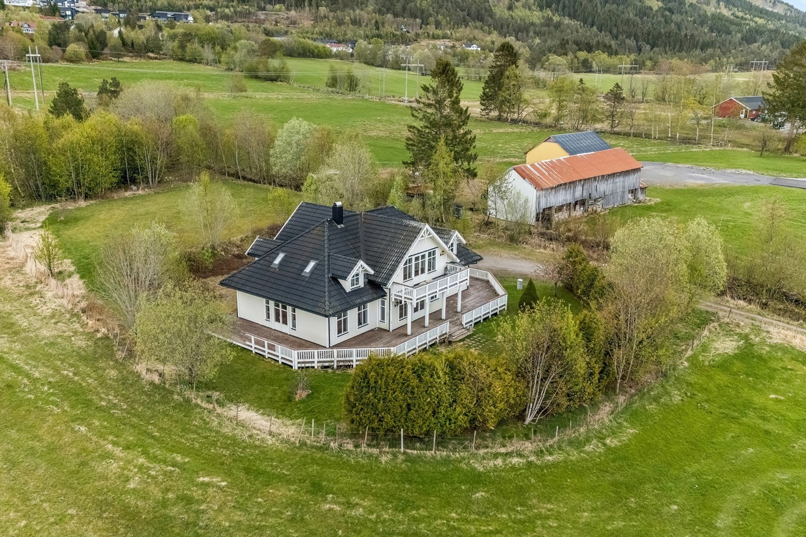 Den nyere eneboligen ligger skjermet til, omkranset av hage og landbruksareal. Galleribilde