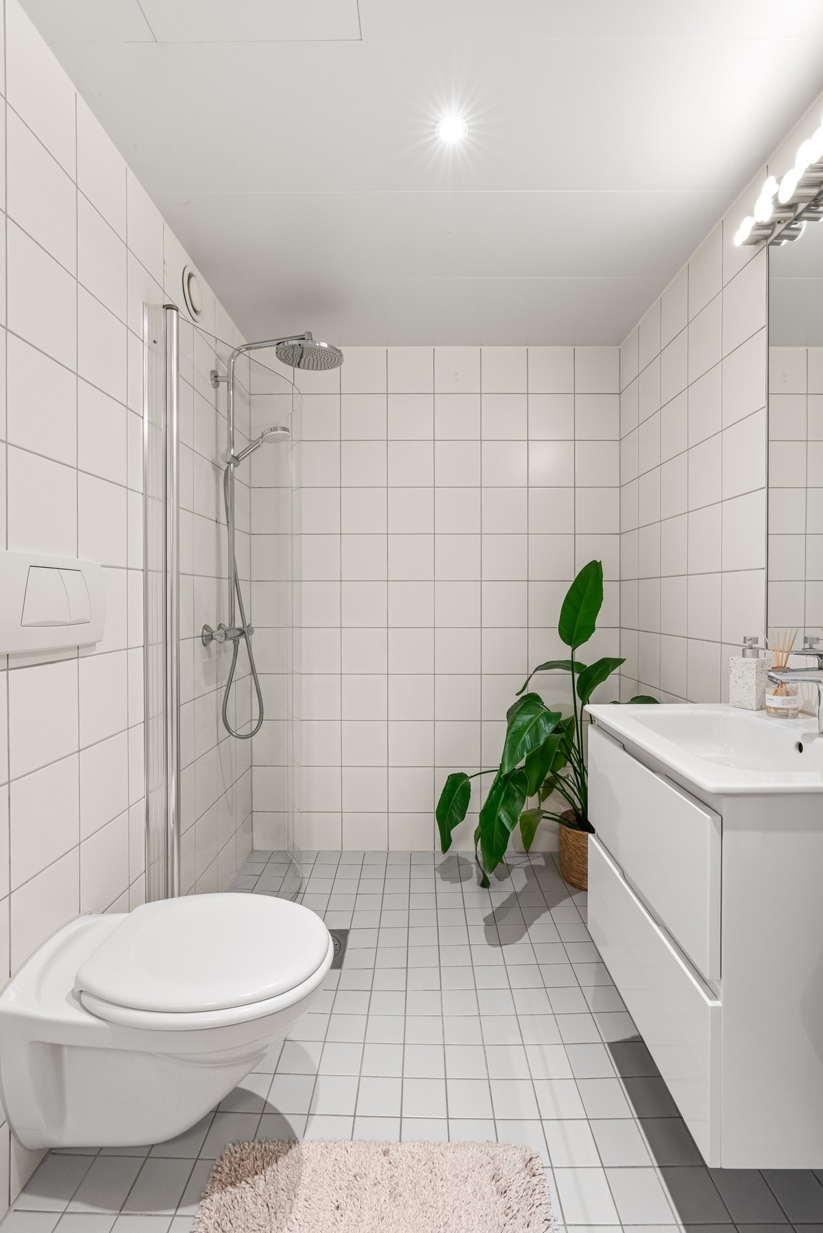 Leiligheten har et meget romslig, flislagt bad med downlights i tak og varmekabler i gulv Galleribilde