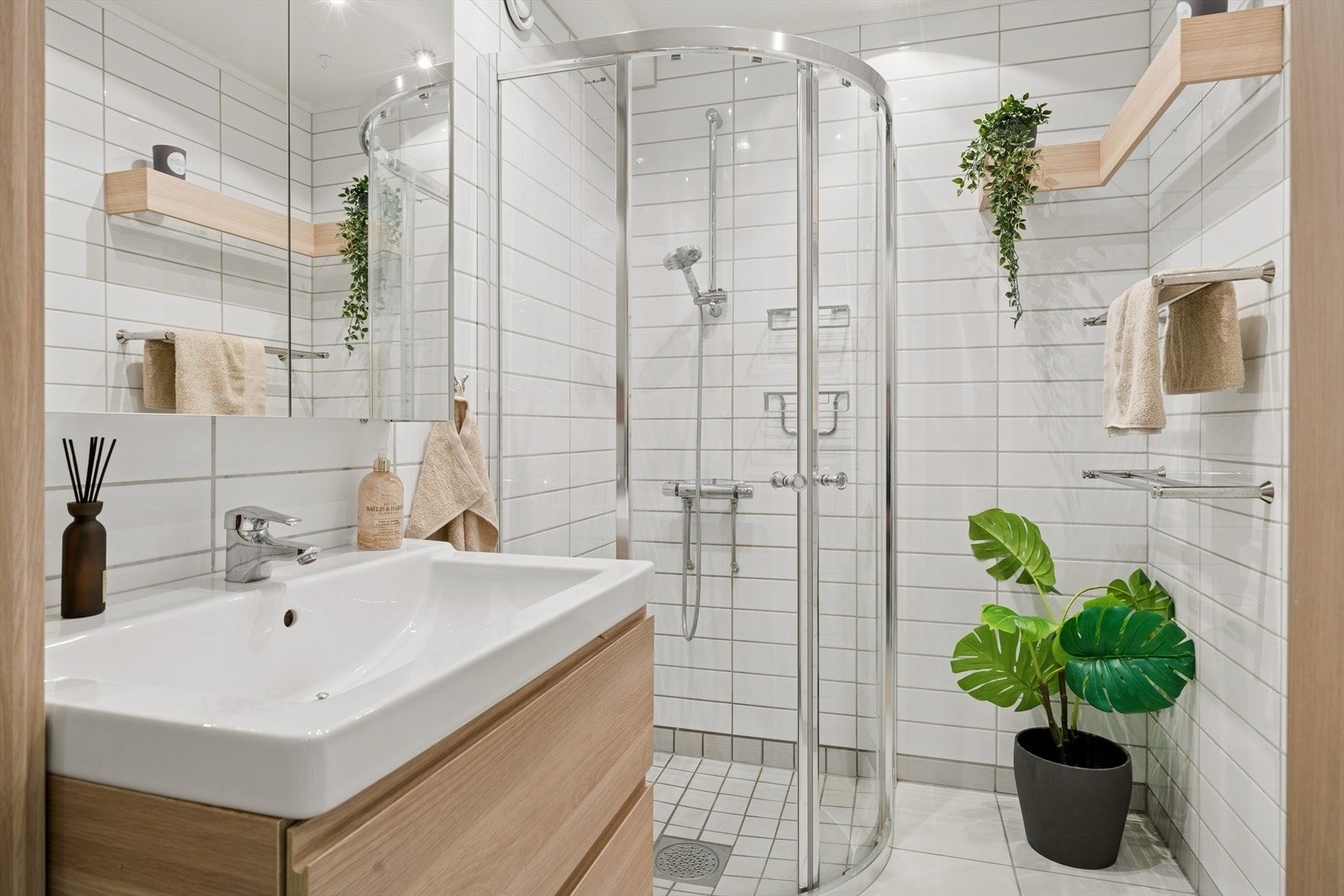 Flott, flislagt bad fra 2013. Badet har en lys og delikat baderomsinnredning med smarte løsninger for oppbevaring. Galleribilde