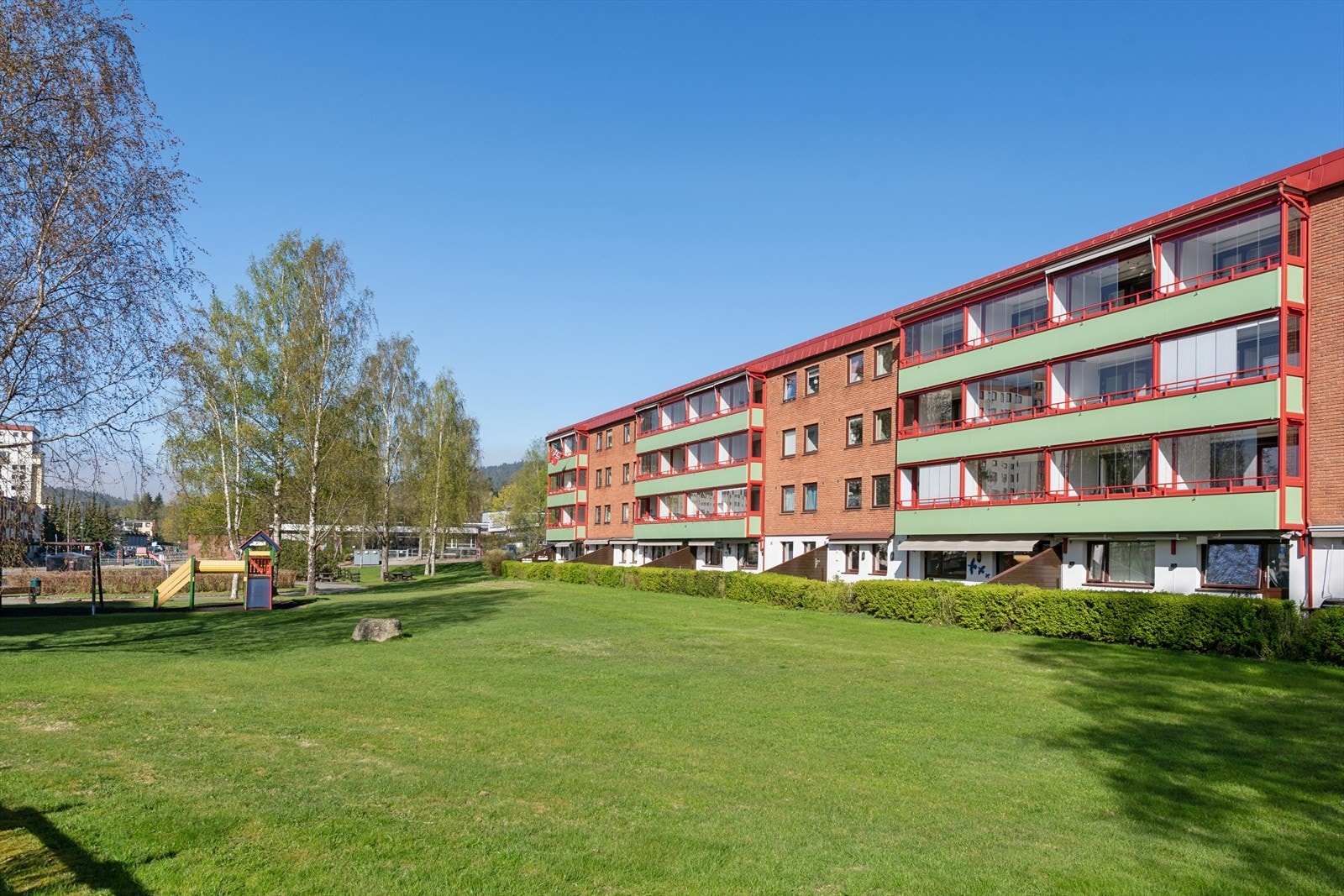 Borettslagets fellesområder er pent opparbeidet med beplantning, grønne plener og soner for lek og opphold. Galleribilde