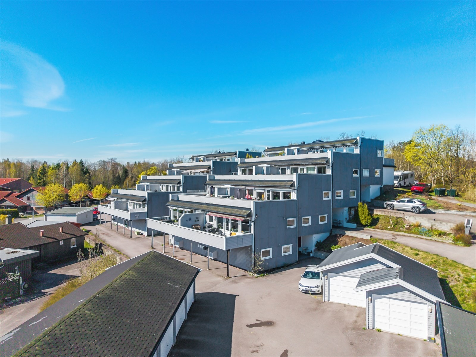 Egen biloppstilling (hvit bil) med el-bil lader, og nærmeste garasjen disponeres av leiligheten. Galleribilde