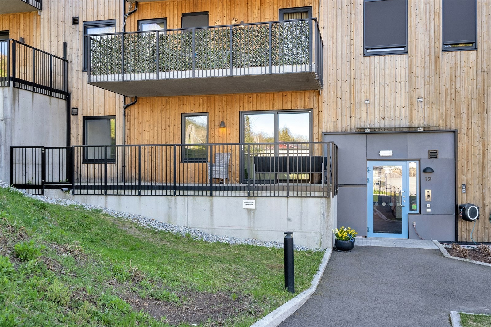 Takoverbygget veranda med rekkverk at stående spiler i lakkert stål, port i rekkverk, samt utelys og stikkontakt - Felles inngangsparti med porttelefon. Galleribilde