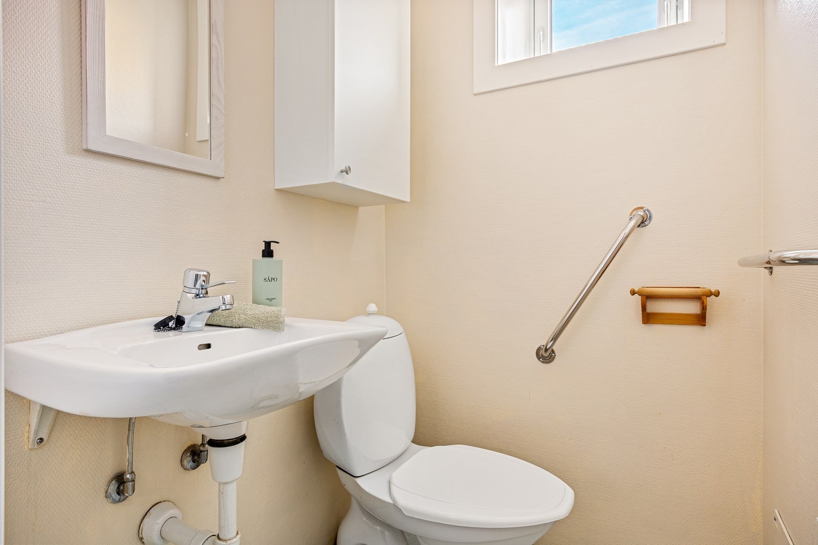 Boligen har separat toalettrom innredet med wc og servant. Rommet har belegg på gulv, tapet på vegger og malt pusset betonghimling. Galleribilde