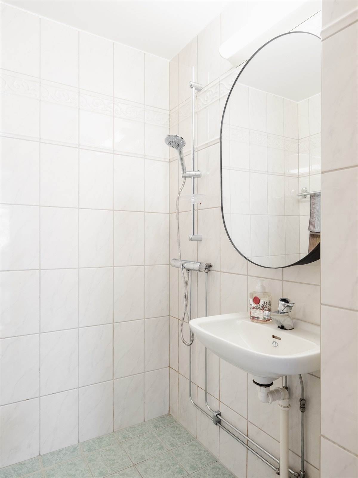 Badet er utstyrt med toalett dusjplass og vegghengt servant med ettgreps blandebatteri. Galleribilde
