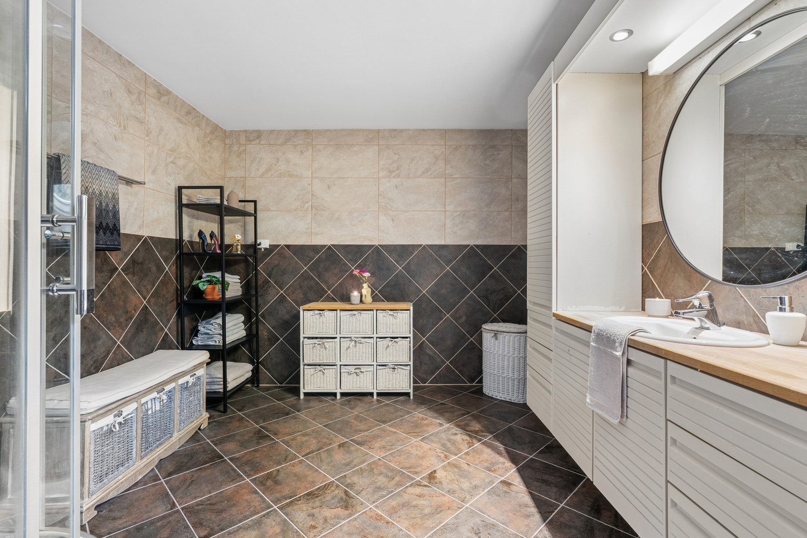 Badet er utstyrt med innredning med nedfelt servant, veggmontert toalett og dusjkabinett. Galleribilde