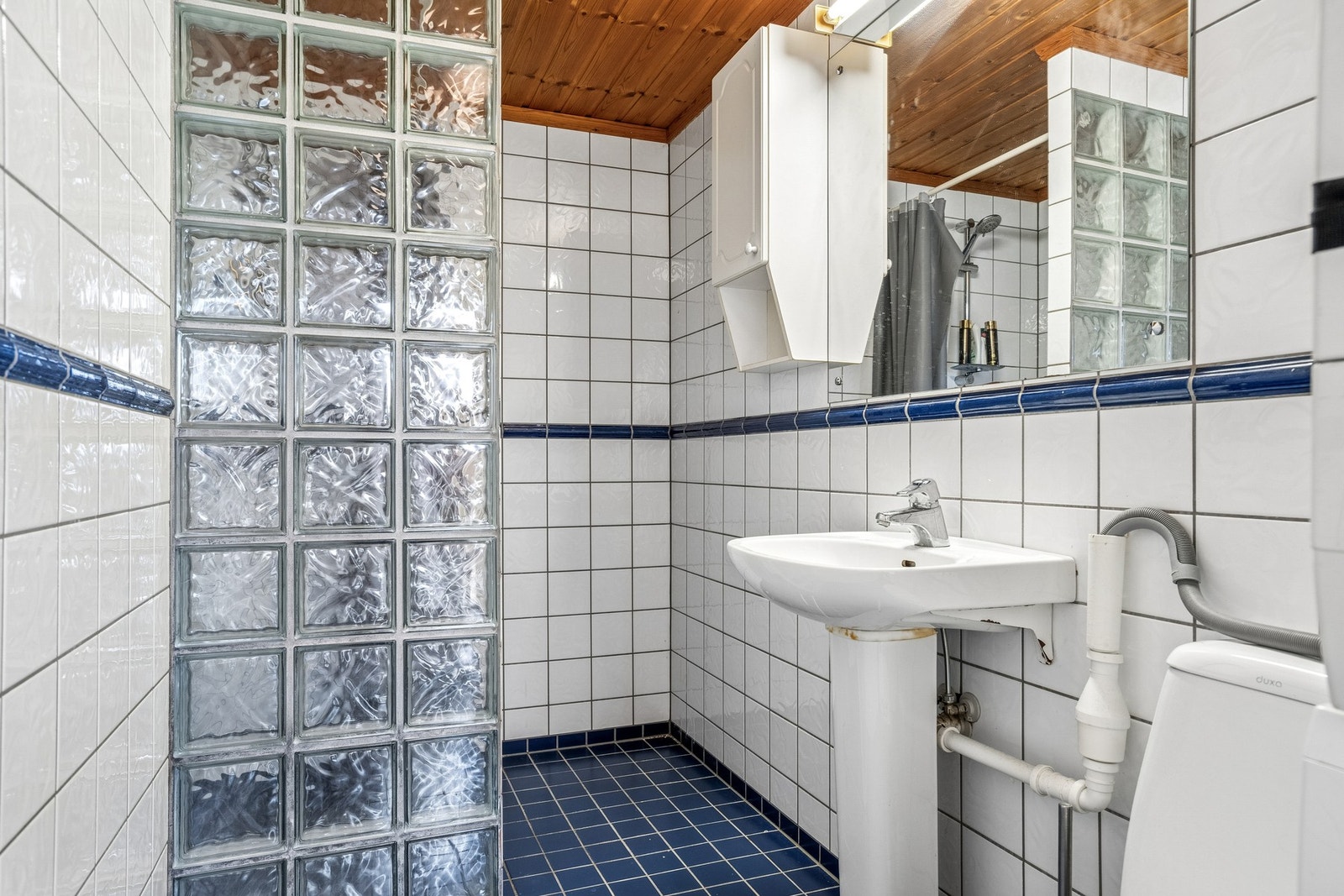 Badet i utleiedelen er flislagt med elektriske varmekabler i gulv. Det er utstyrt med servant, toalett, dusjvegger/hjørne og opplegg for vaskemaskin. Galleribilde
