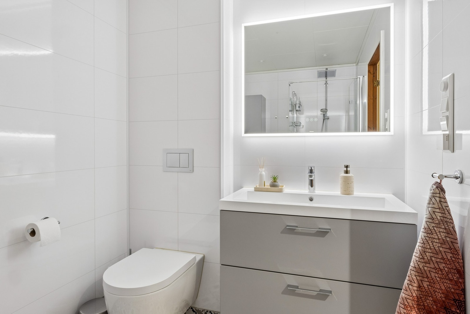 Badet er oppgradert i 2020 med flott tidløs innredning, baderomsplater på vegger, flis på gulv, vegghengt wc og regnfallsdusj. Galleribilde