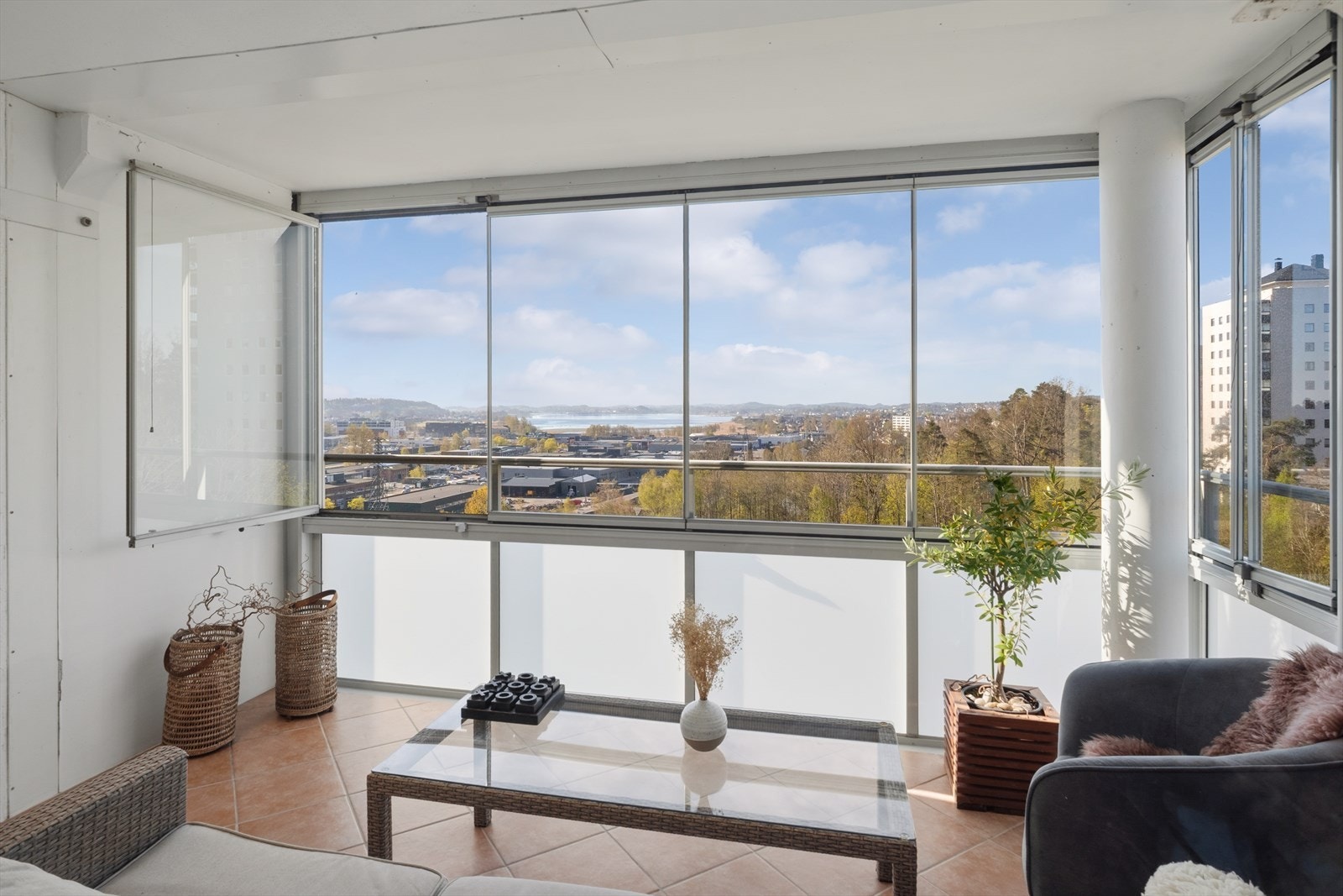 Den innglassede balkongen på 10 m² har flislagt gulv og fungerer som en forlengelse av stuen store deler av året. Galleribilde