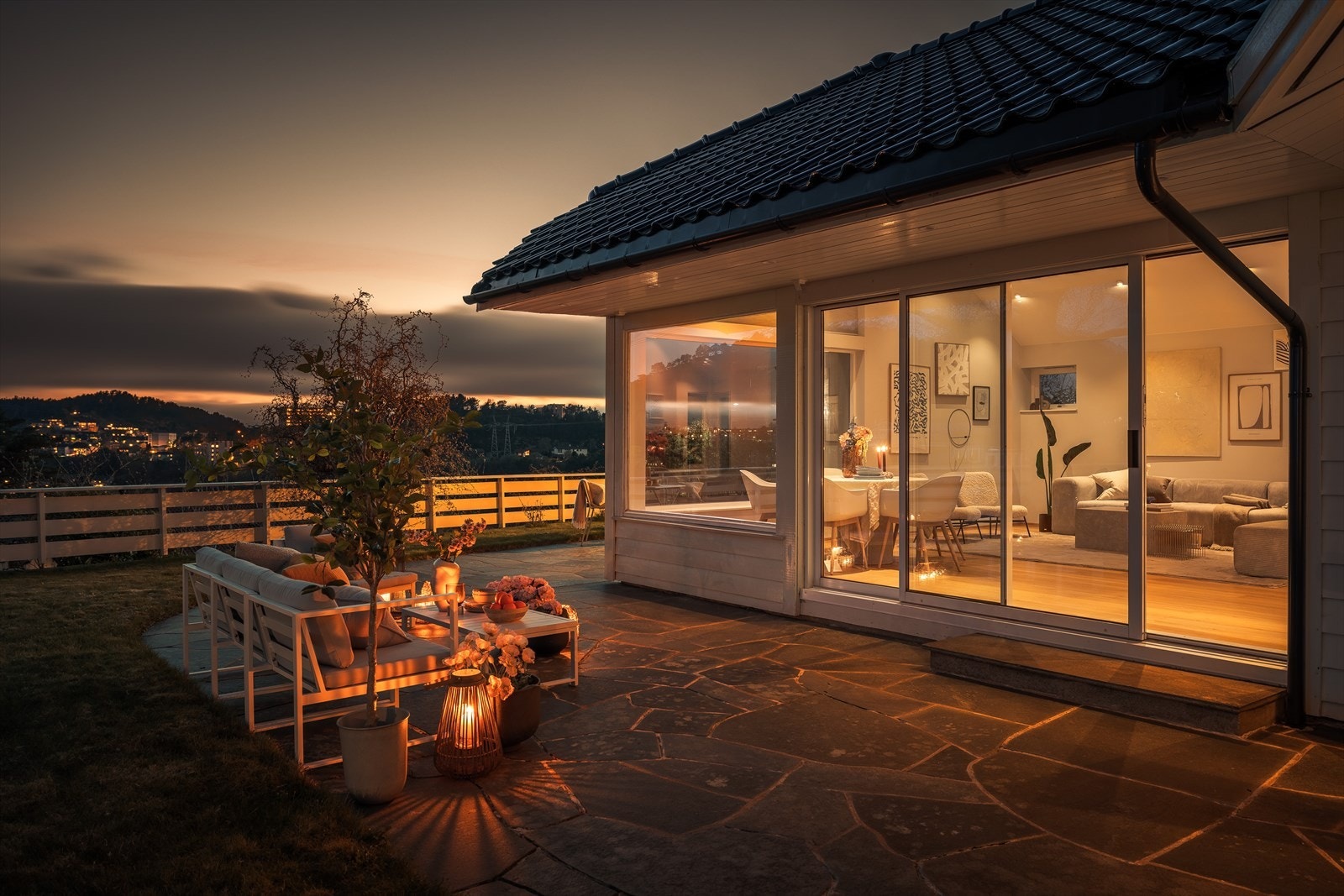 Den vestvendte uteplassen blir en naturlig forlengelse av stuen, med en skyvedør i aluminium fra 2009 som åpner opp for kveldssolen. Galleribilde