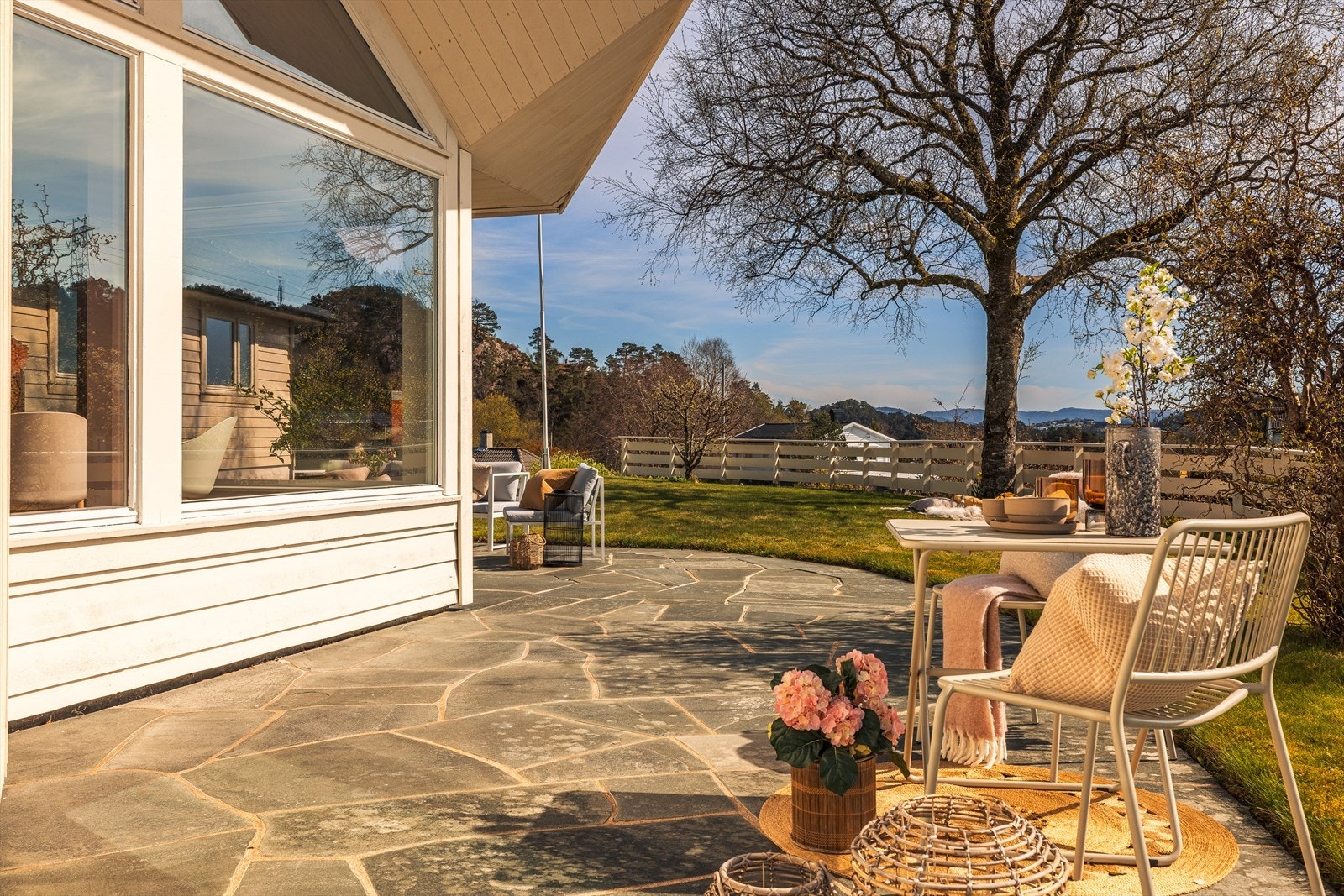 Tomten er opparbeidet med murer, bed og et stort terrassedekke. Galleribilde