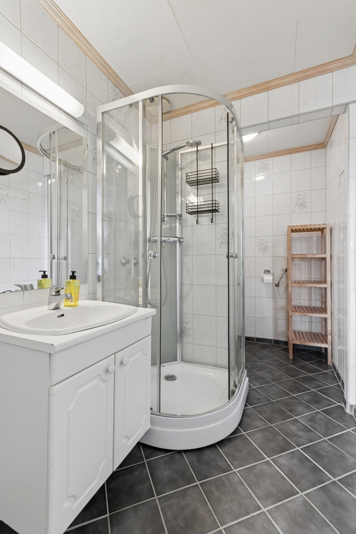 Badet i leiligheten har flislagt gulv med elektriske varmekabler og er utstyrt med dusjkabinett. Galleribilde