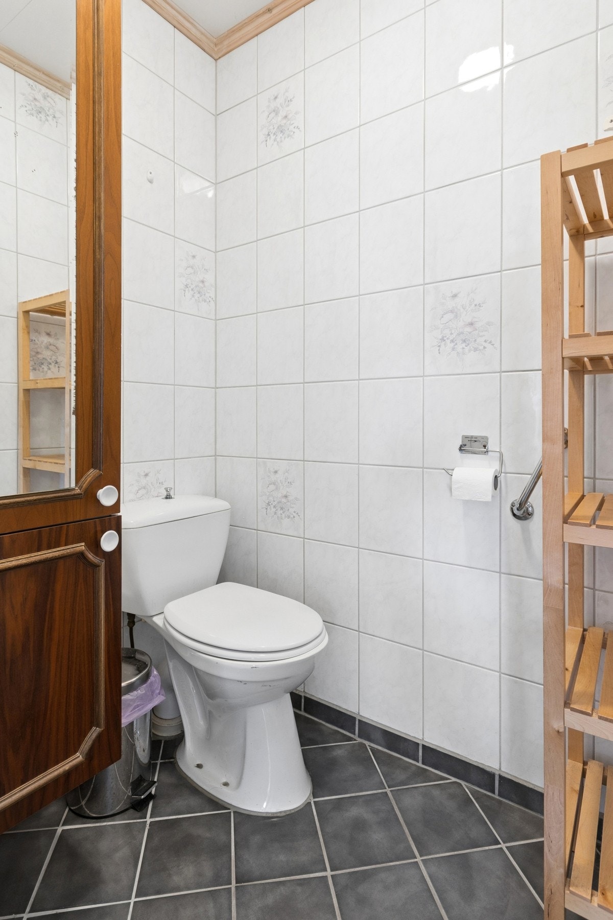 Badet har fliser på veggene, innredning med servant og toalett. Galleribilde