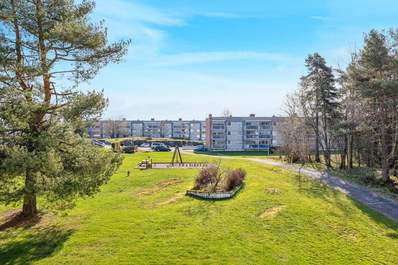 Grønne og romslige fellesarealer i et veletablert borettslag med lekeplass og hyggelige uteområder. Galleribilde