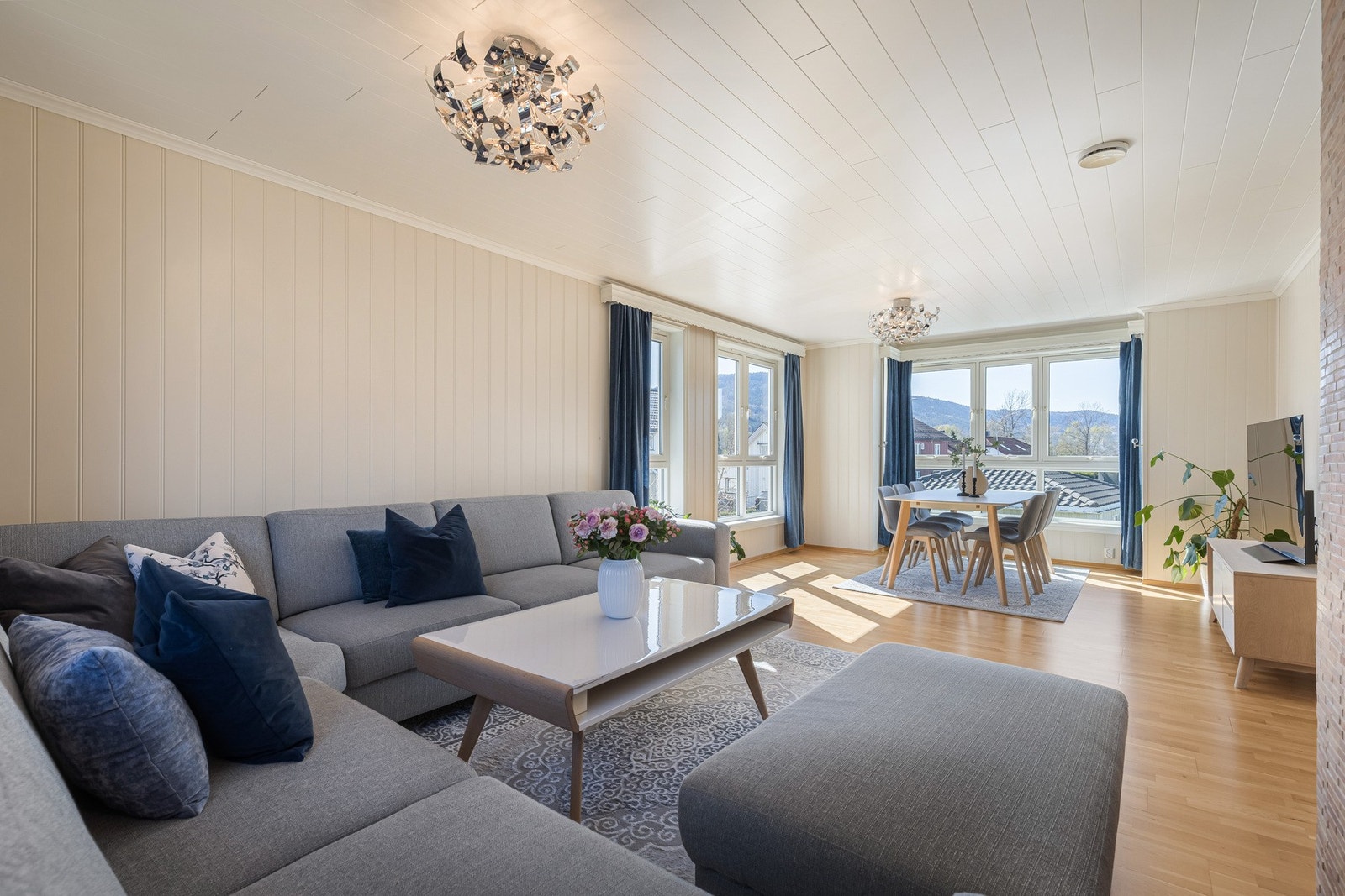 Innbydende stue med god plass til både sofagruppe og spisebord. En naturlig samlingsplass for familie og gjester. Galleribilde