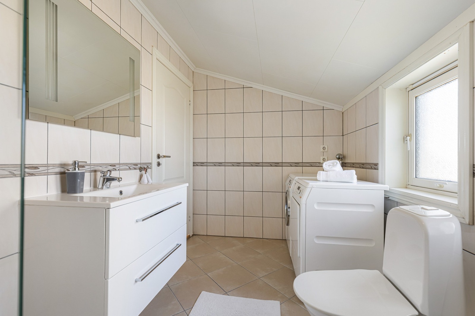 Praktisk bad/vaskerom med god plass til vaskemaskin og oppbevaring. Galleribilde