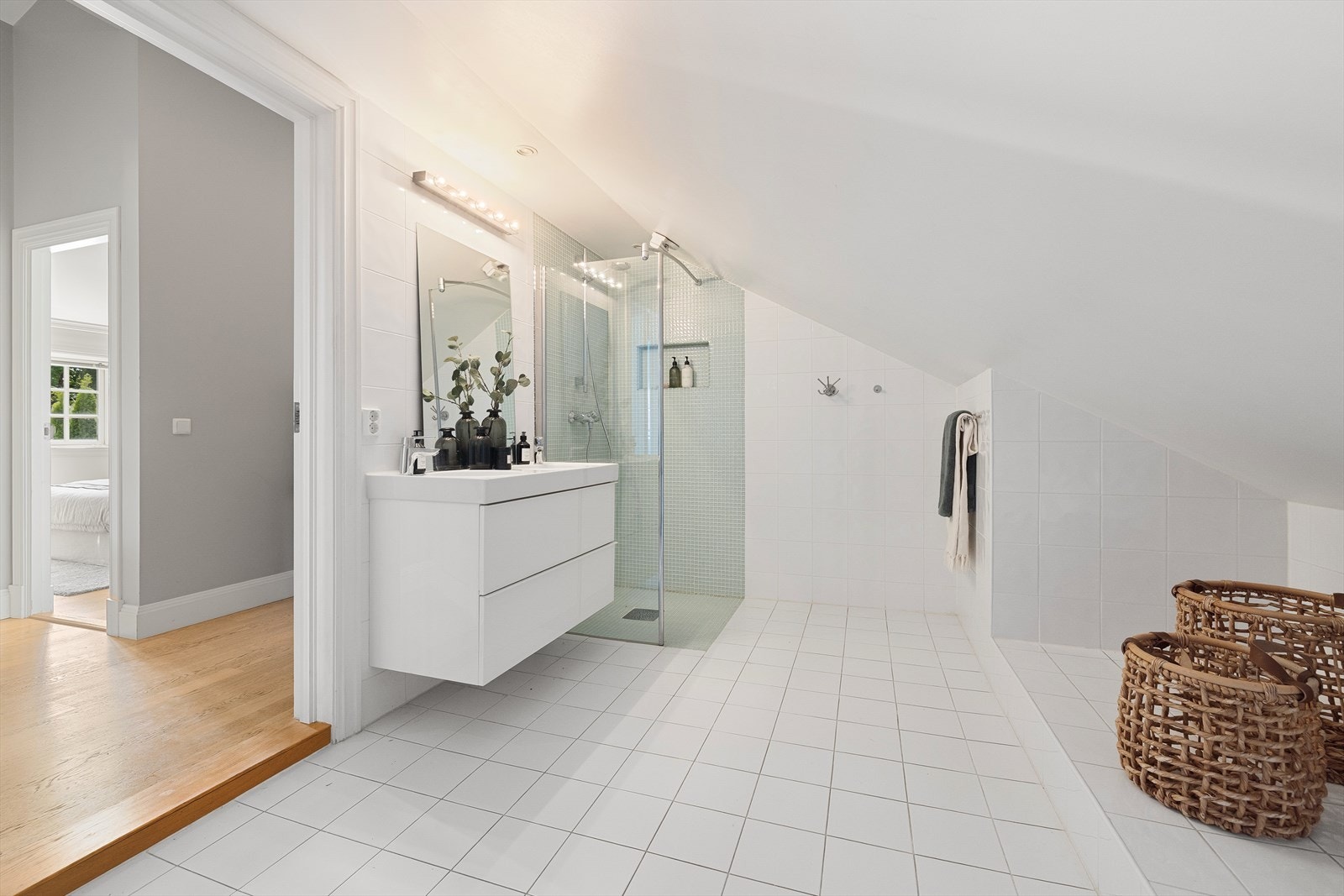 Det andre romslige badet i 2. etasje ble pusset opp i 2013. Fliser på gulv med varmekabler. Veggene er flislagt med 20x20 cm fliser, og det er mosaikkfliser i dusjsonen. Belysningen består av spotter i taket og lampe over speil. Galleribilde
