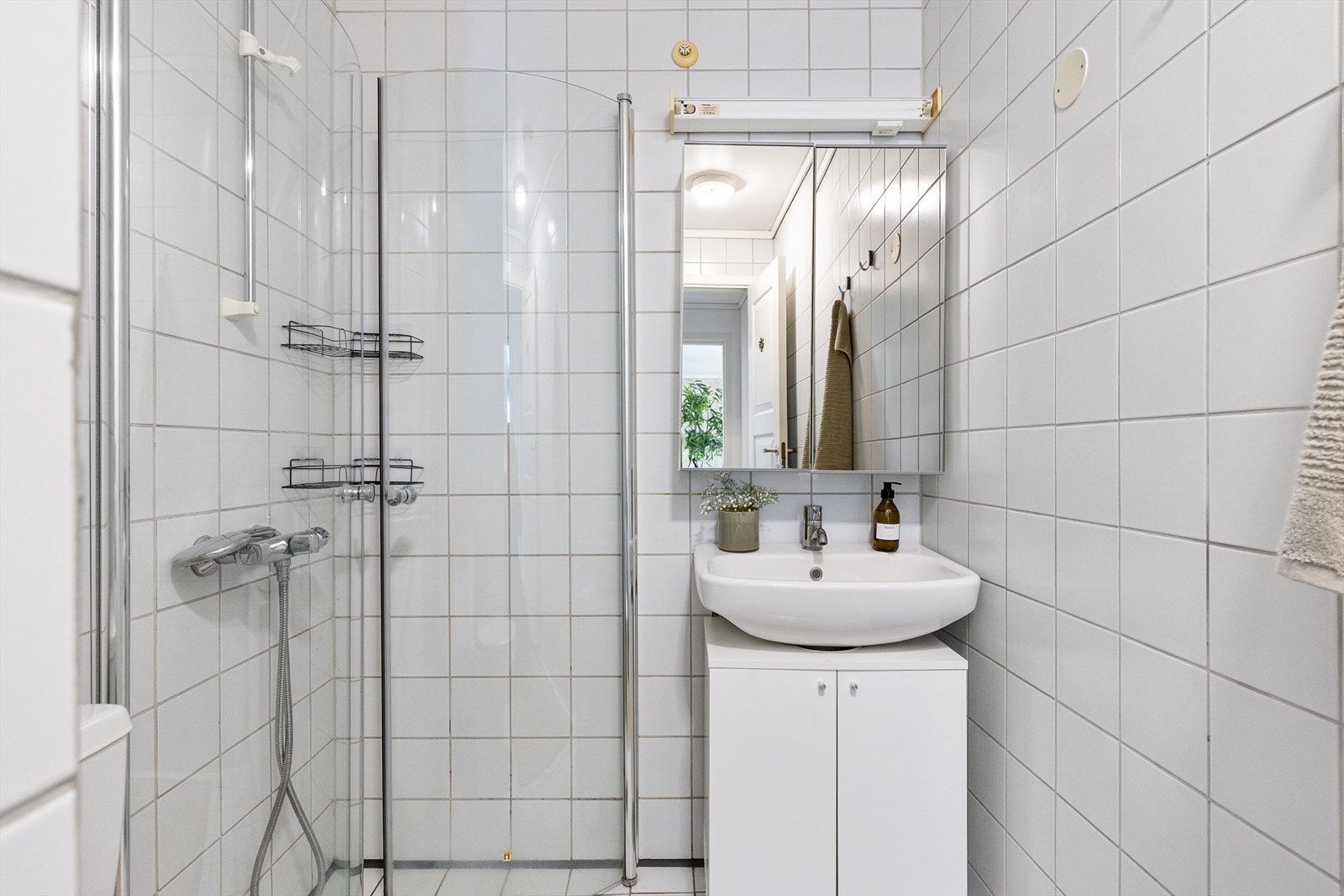 Badet er utstyrt med mekanisk avtrekk, opplegg for vaskemaskin, innfellbare dusjdører, wc og servant med ettgreps blandebatteri. Galleribilde