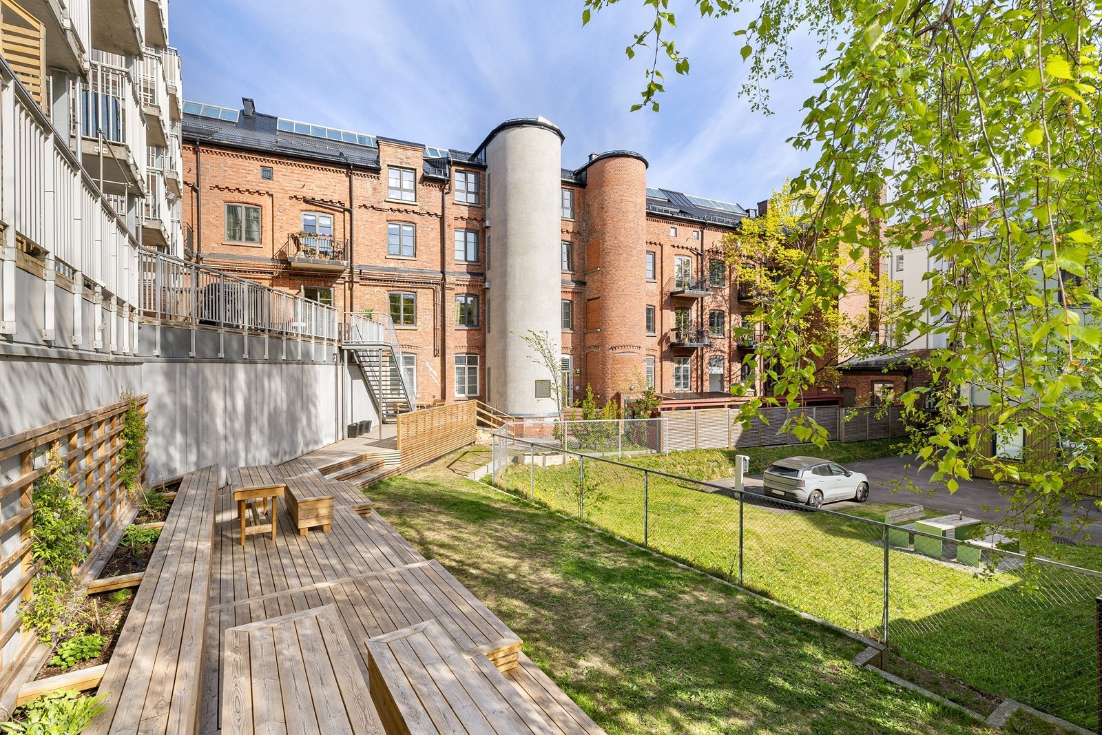 Bakgården har kombinasjon av tredekke, grøntareal og karakteristisk eldre teglbebyggelse Galleribilde