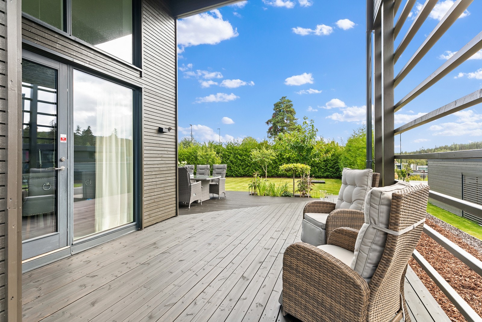Utgang fra stuen til trelagt terrasse - hele hagen foran seg. Galleribilde