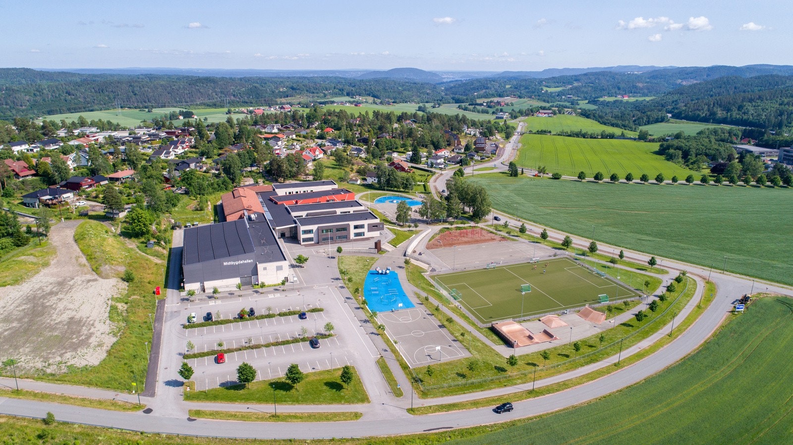 Midtbygda skole med idrettshall, fotballbane og skateanlegg - sentralt i nabolaget. Galleribilde