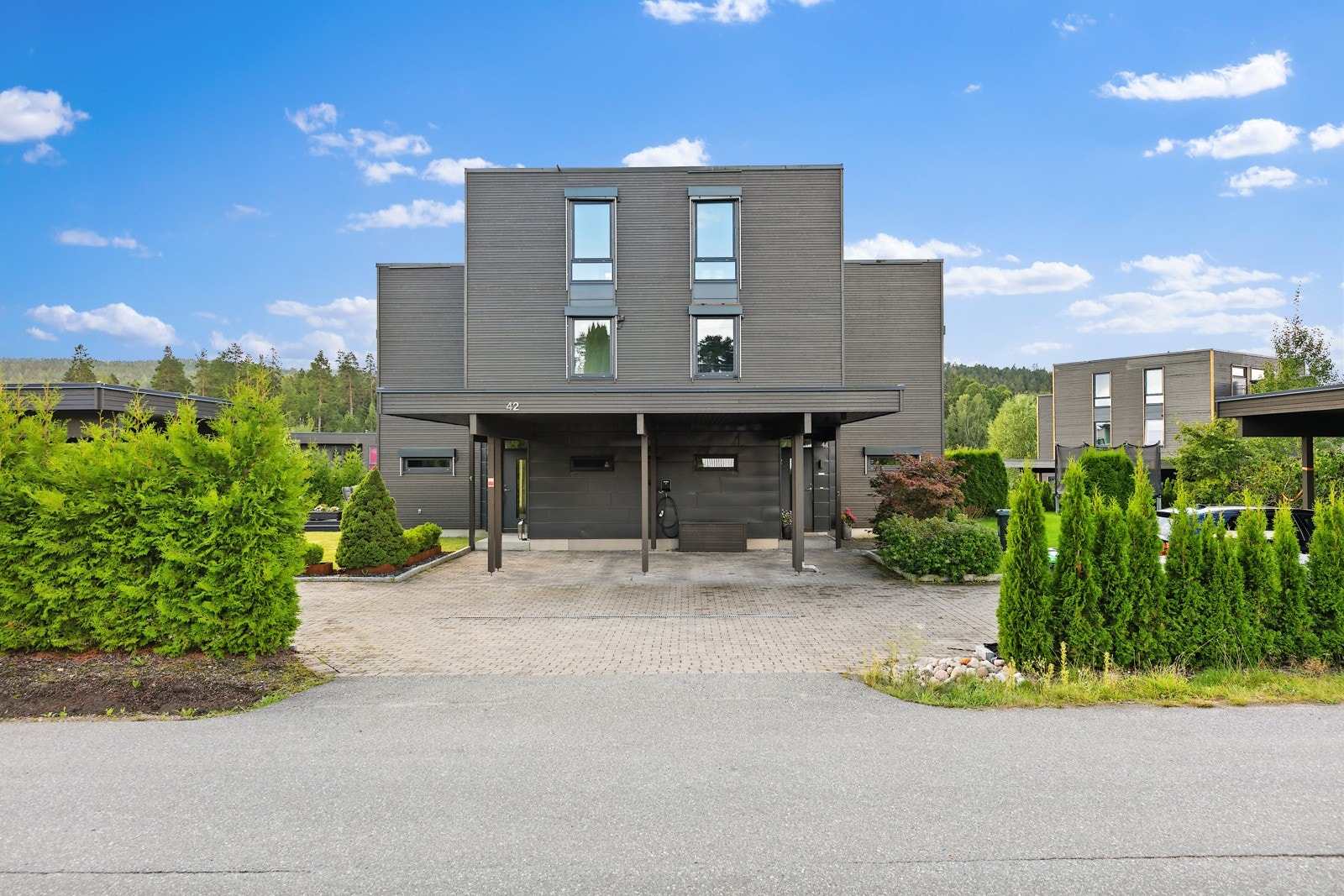 Ren og tidløs funkisfasade mot Katrineåsveien, med carport. Galleribilde