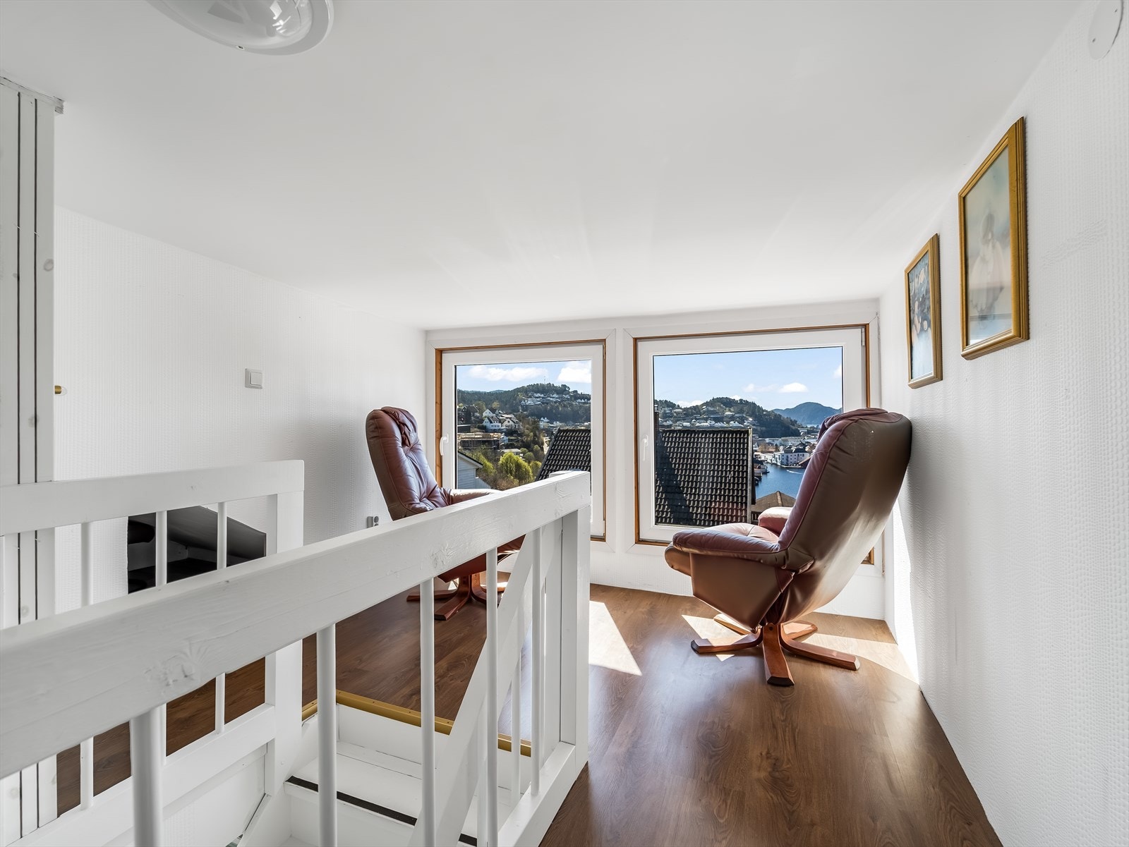Loftstue med store vinduer som gir utsikt og naturlig lys. Her er det lav takhøyde. Galleribilde