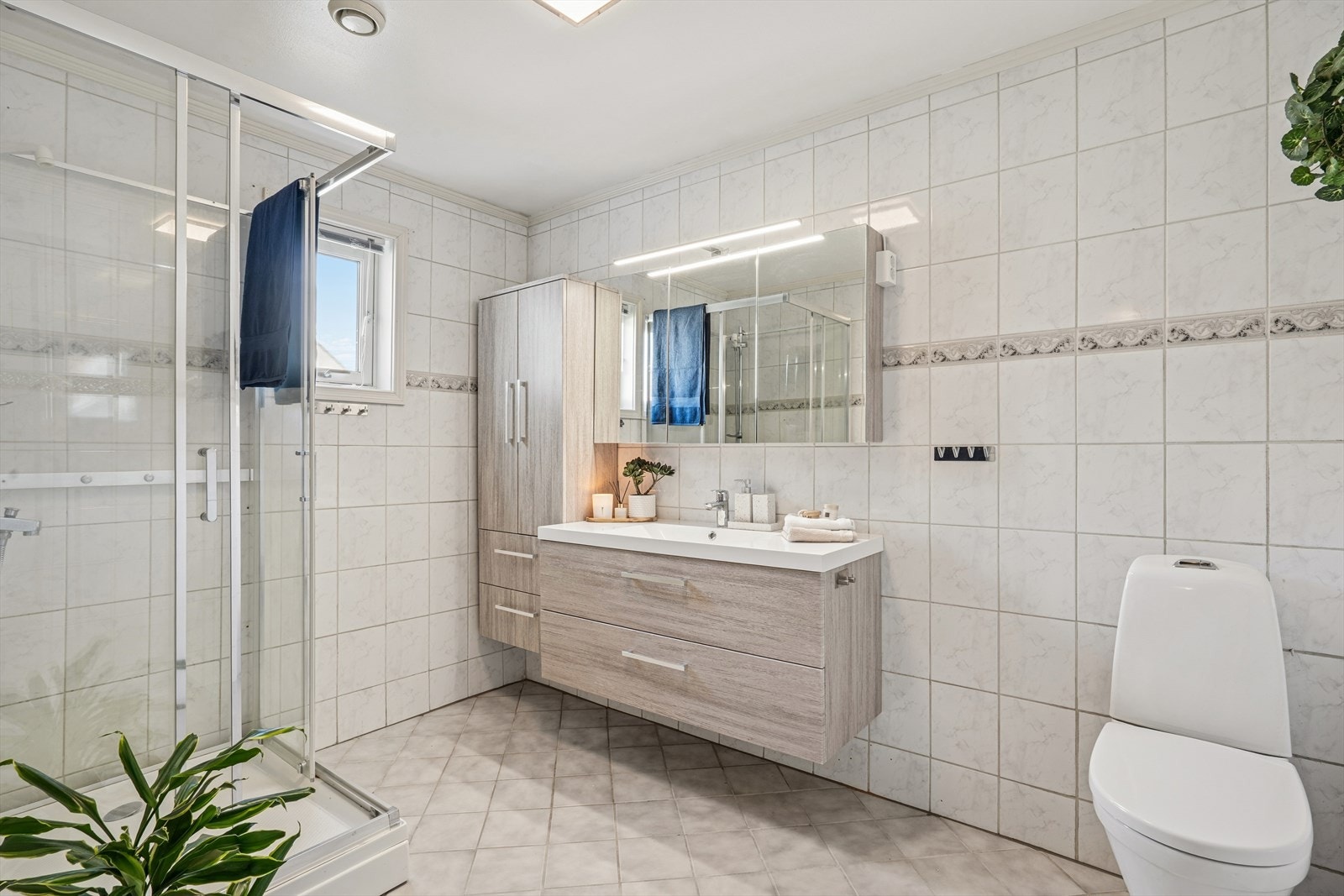 Flislagt baderom fra byggeår. Badet har godt med oppbevaringsplass i høyskap og speilskap. Galleribilde
