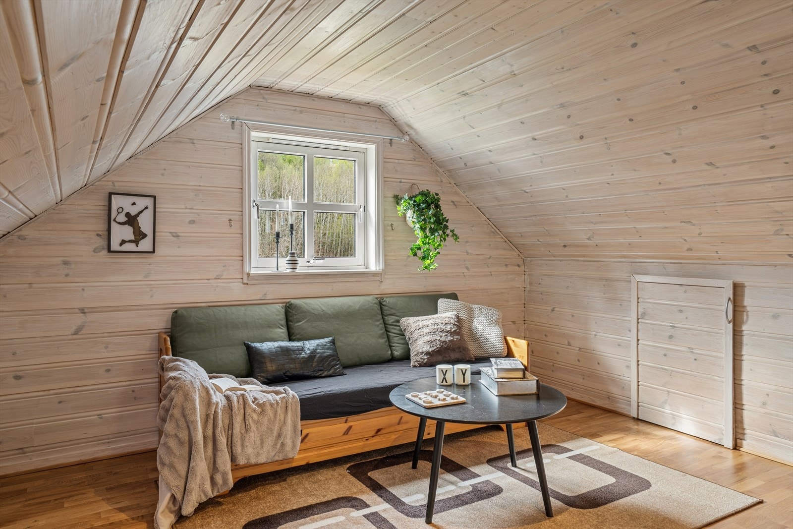 Panel på vegger og i tak skaper en lun og koselig atmosfære i loftsstuen. Galleribilde