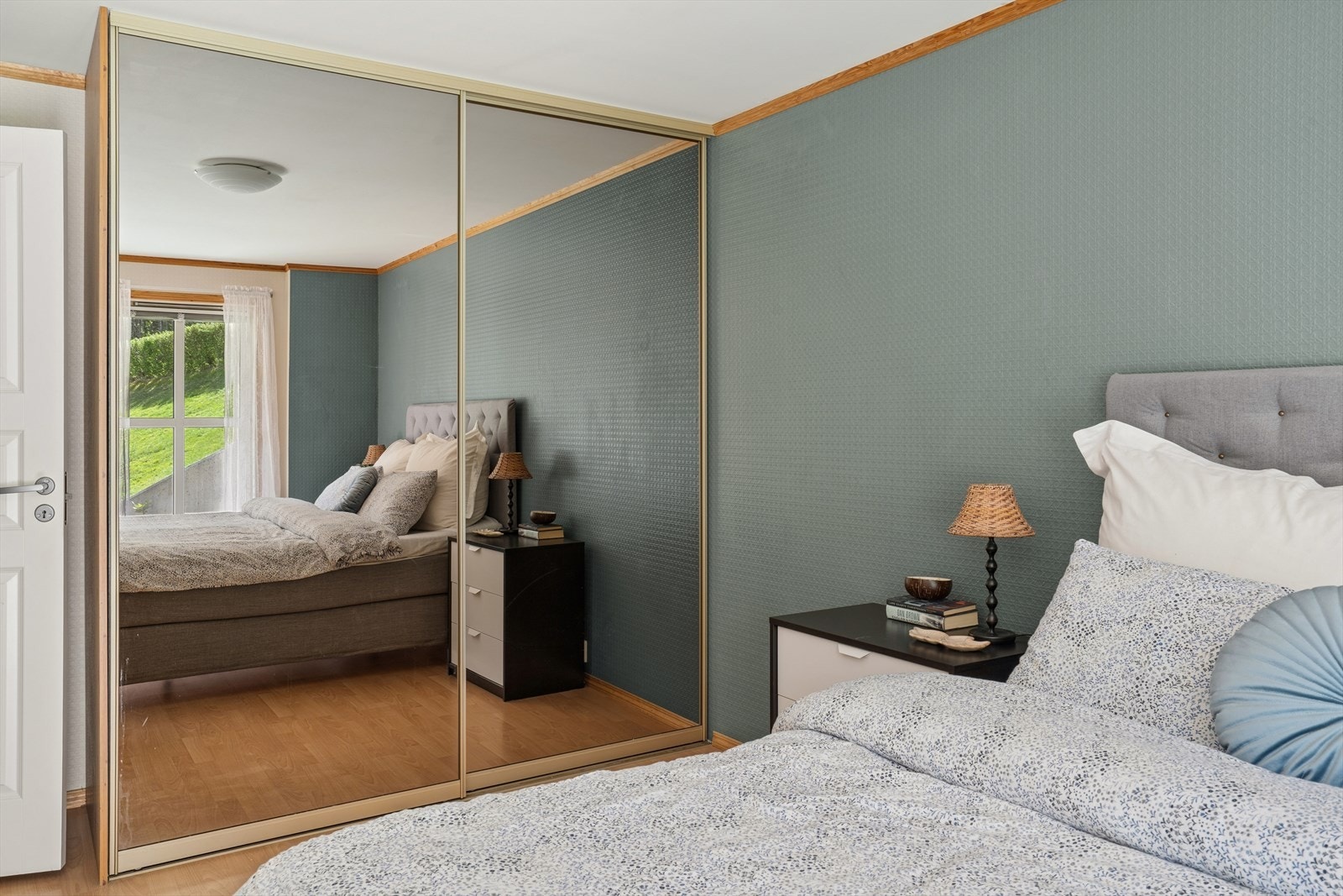 En stor skyvedørsgarderobe med speilfronter gir rikelig med oppbevaringsplass. Galleribilde