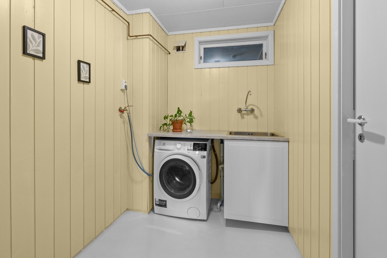 Praktisk vaskerom med opplegg for vaskemaskin og en 200-liters varmtvannsbereder fra 2014. Galleribilde
