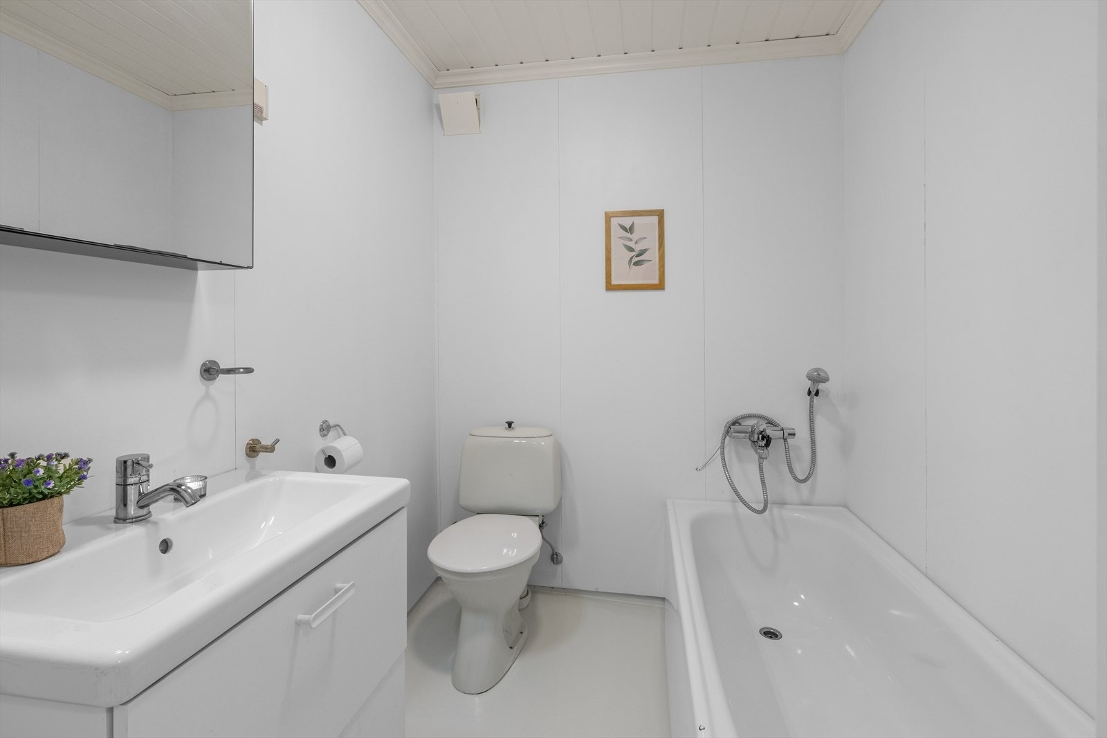 Badet i underetasjen er utstyrt med badekar, servant og toalett. Veggene har baderomsplater. Galleribilde