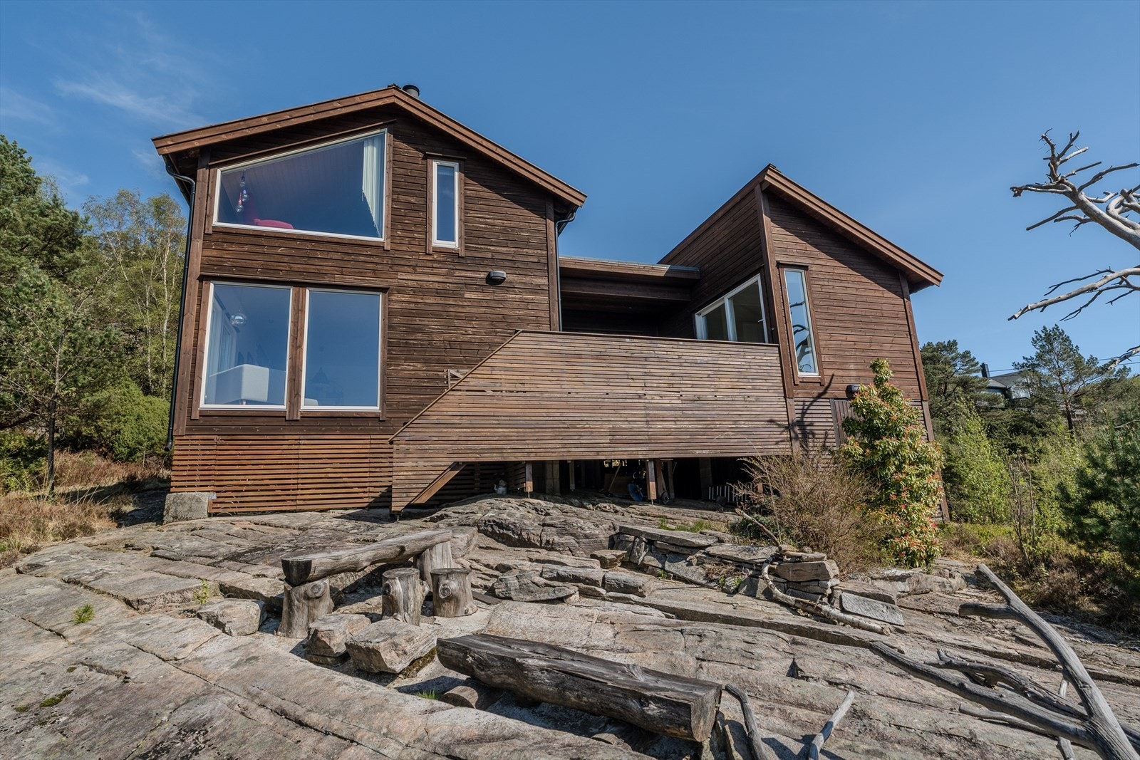 Dette er en moderne og særegen hytte med naturskjønn beliggenhet - store vindusflater som slipper naturen inn, lune uteområder på svaberg og gjennomført trearkitektur som gir en varm og eksklusiv atmosfære! Galleribilde