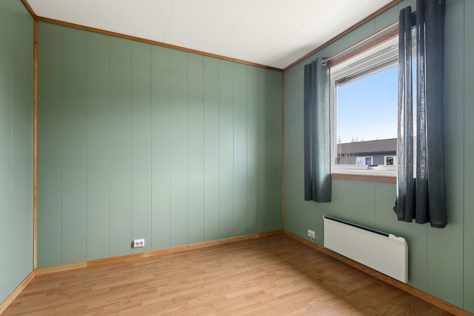 Vegger med malte panelplater og laminat på gulvet. Galleribilde